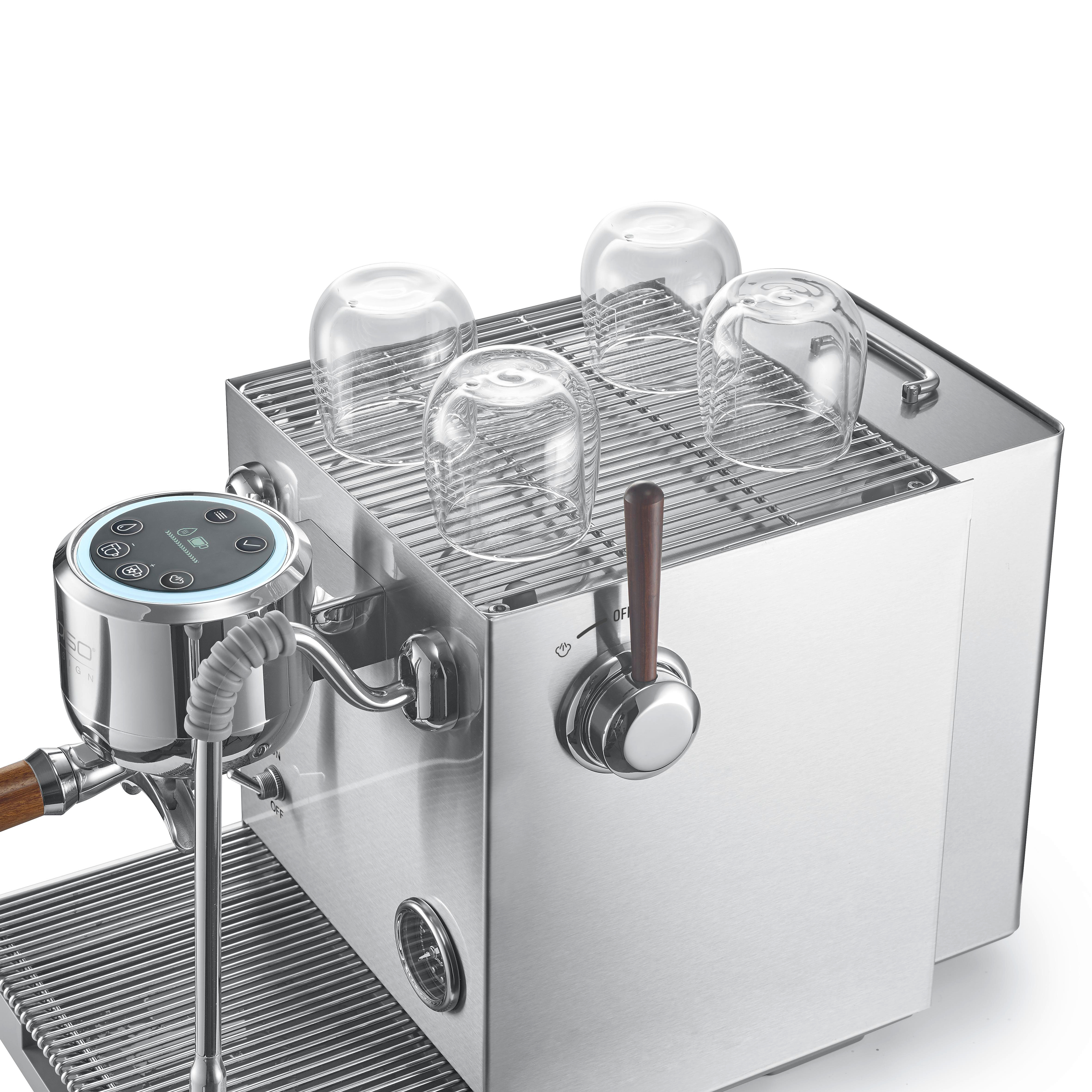 Eine silberne Espressomaschine mit vier leeren Gläsern auf dem Rost.