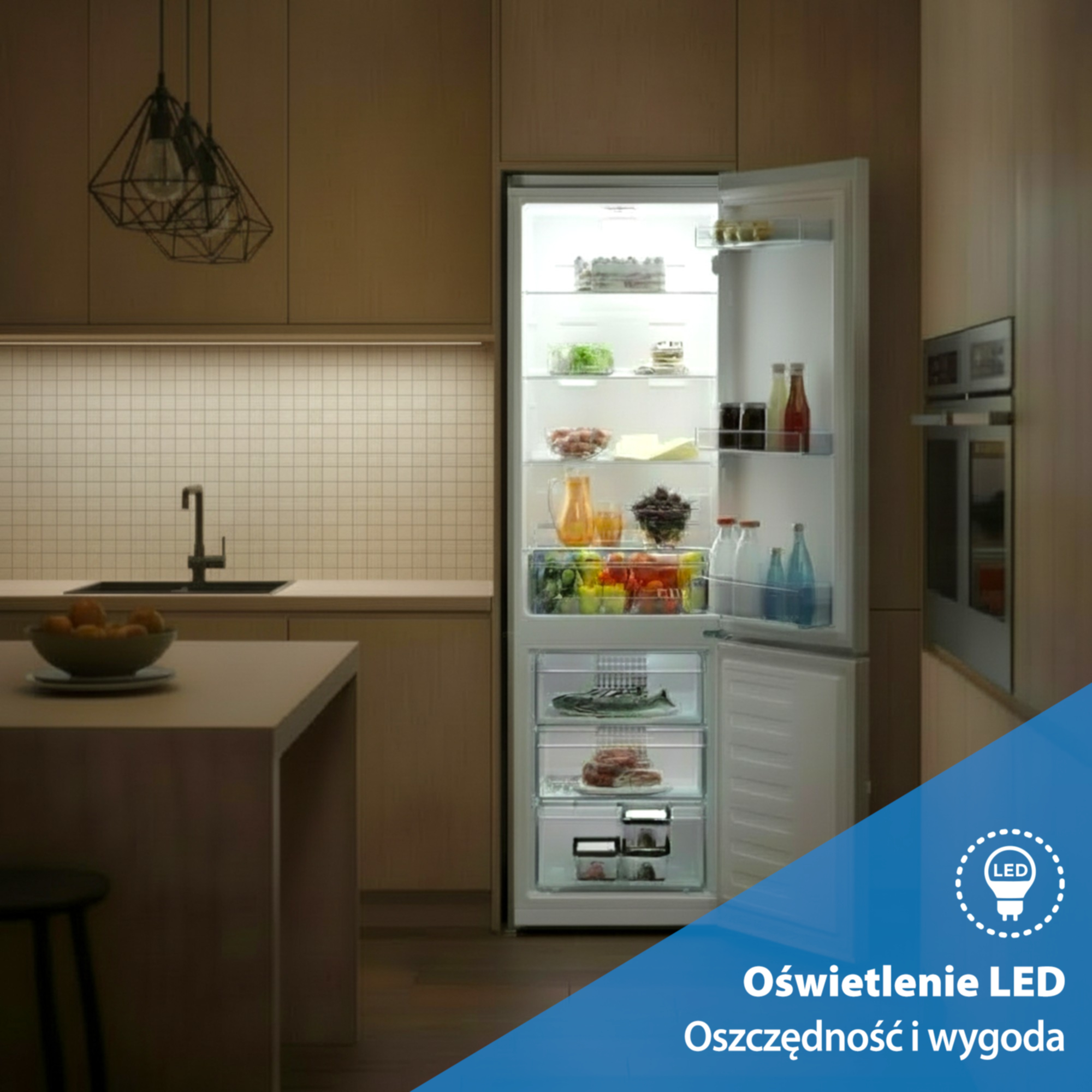 Otwarta lodówka z oświetleniem LED, wypełniona jedzeniem. Kuchnia w tle.