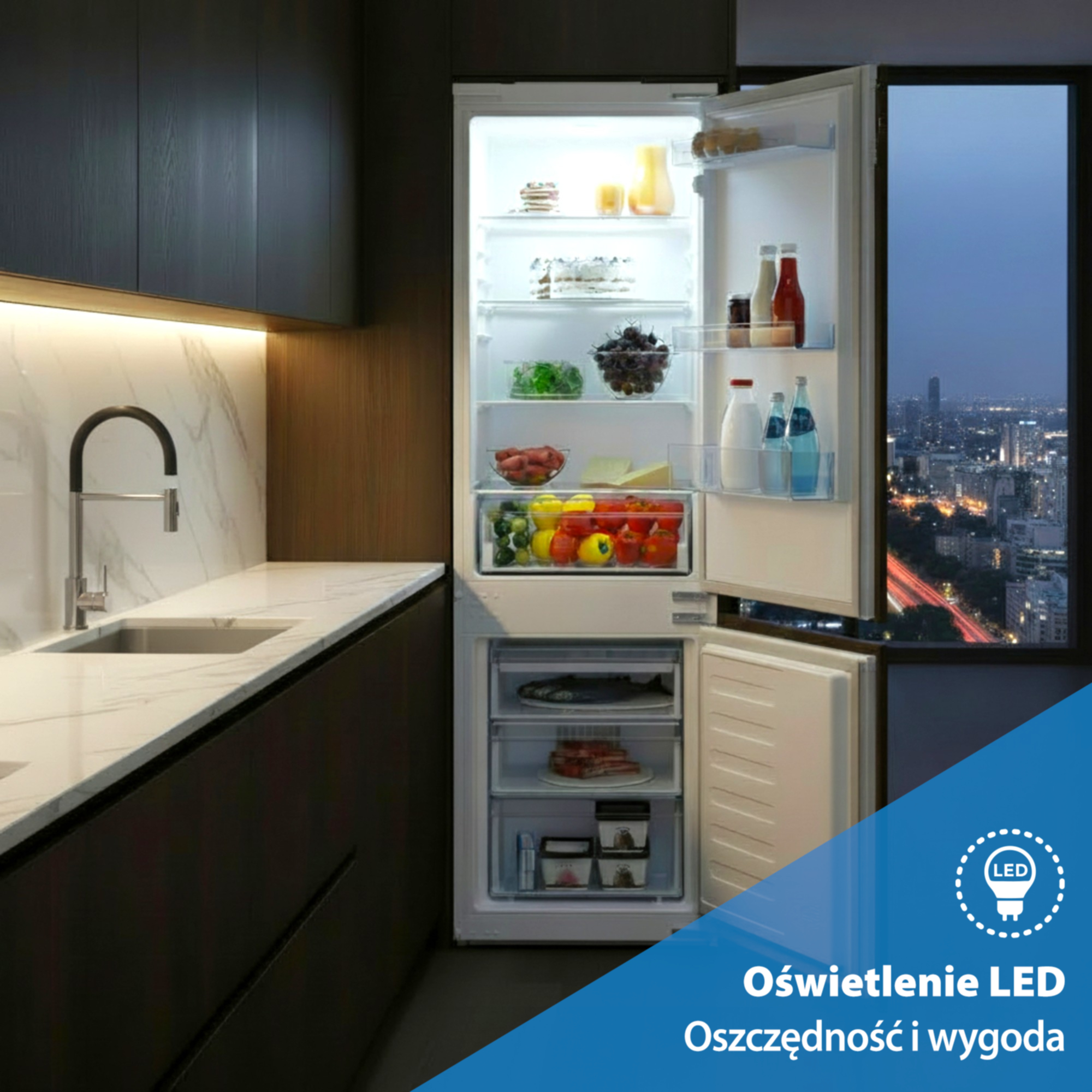 Oświetlona lodówka pełna jedzenia, z widokiem na miasto nocą w tle.