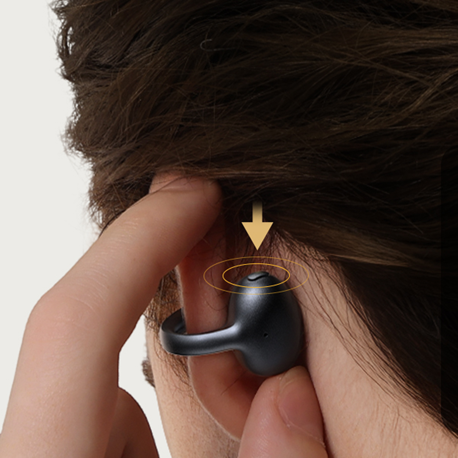 Una mano inserta un auricular negro en una oreja. Una flecha hacia abajo indica colocación.