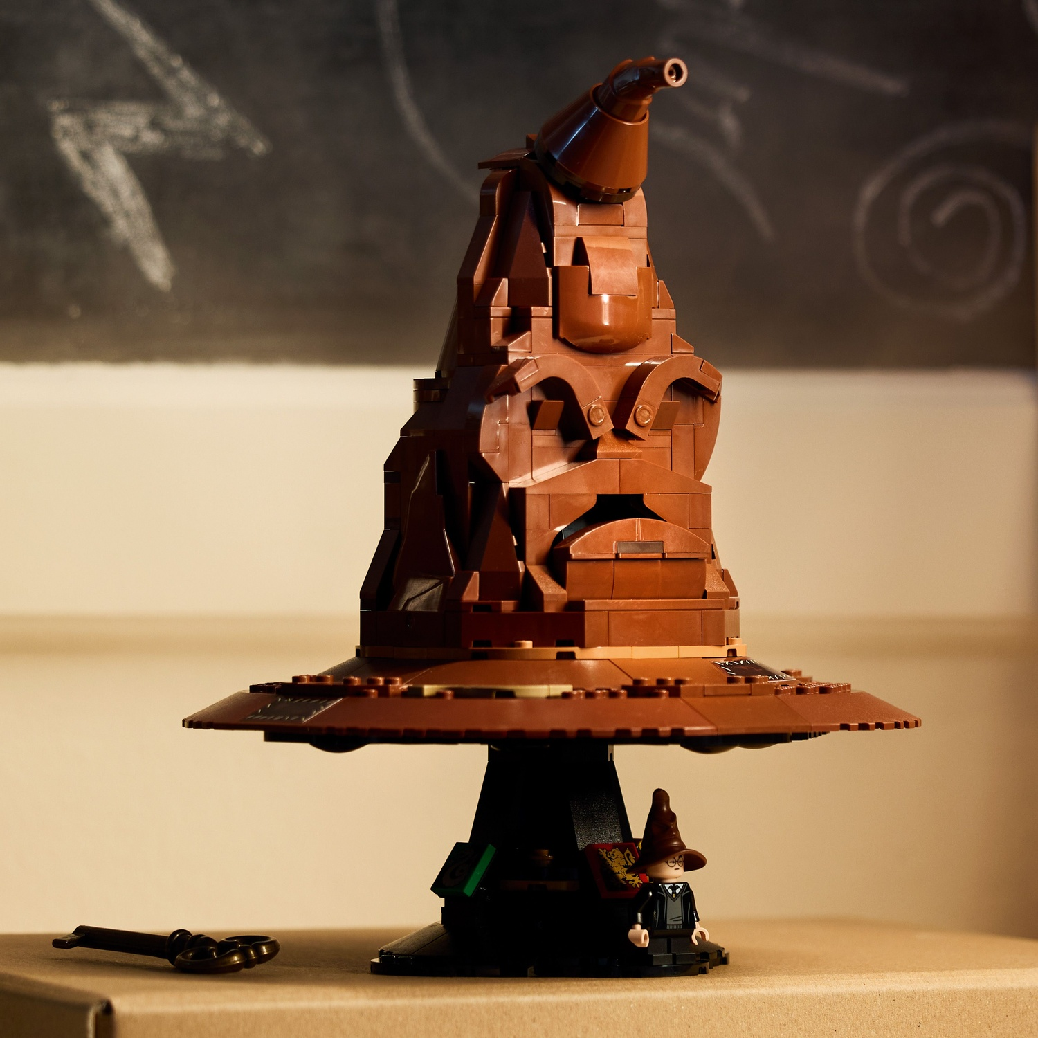 A brown Lego Sorting Hat with a minifigure and a key.