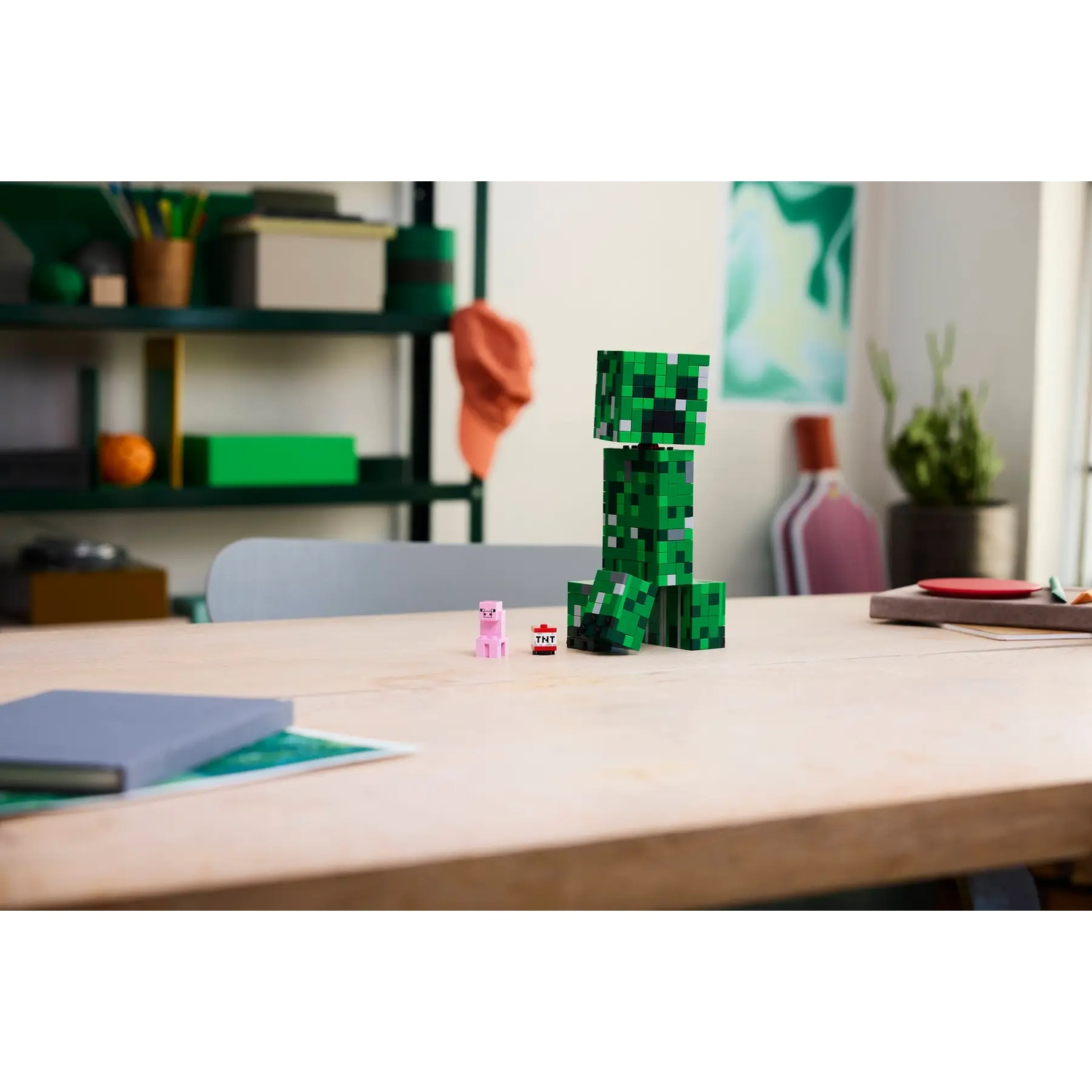 A Minecraft Creeper and Pig figure stand on a wooden table.