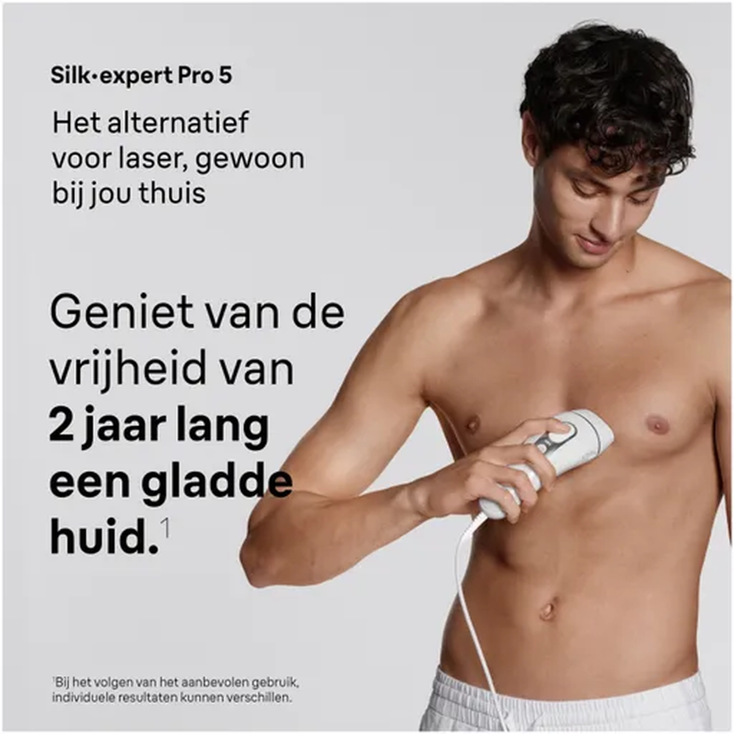 Een man gebruikt een wit IPL-ontharingsapparaat op zijn borst. Het heeft een snoer.