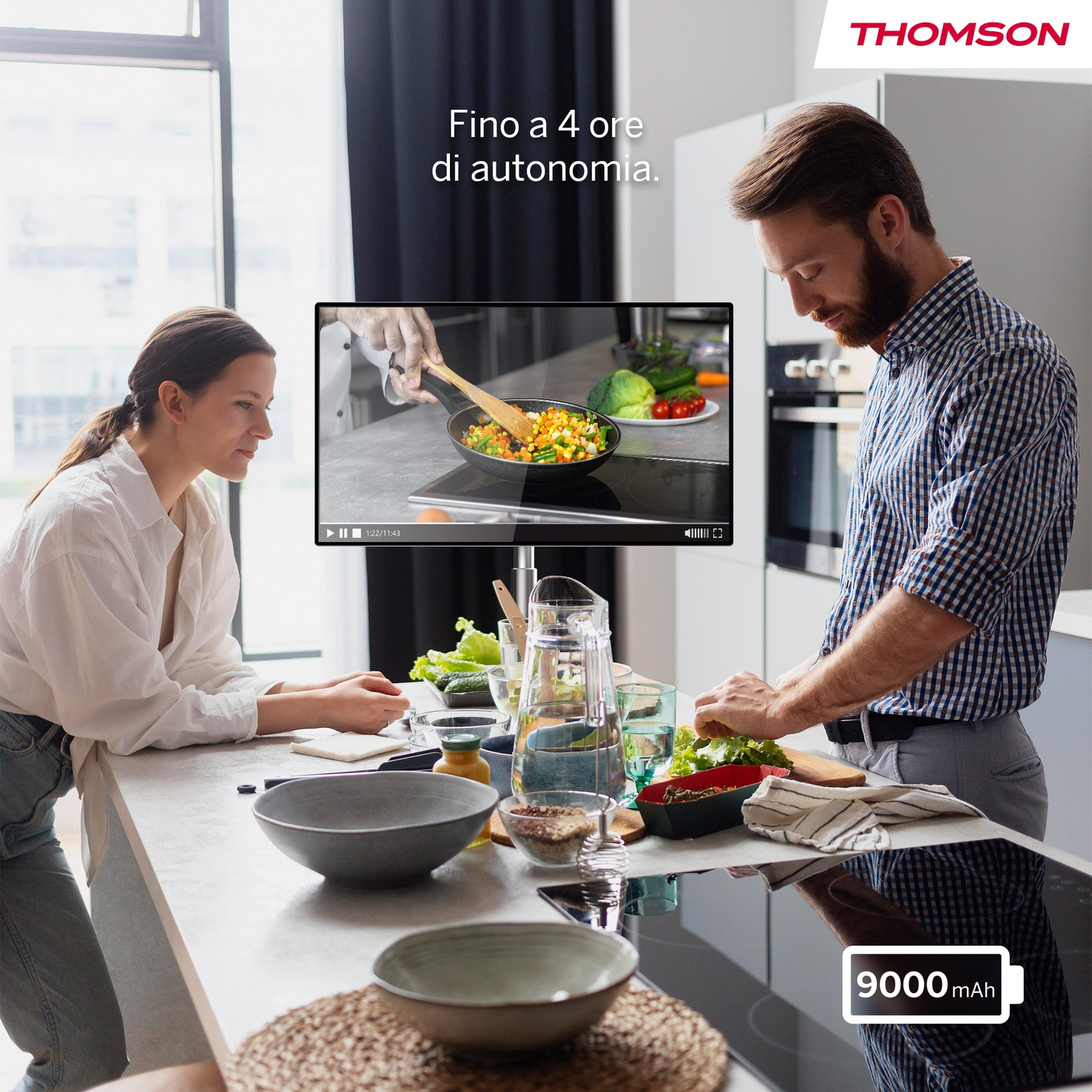 Uomo e donna in cucina guardano schermo. 4 ore autonomia. 9000 mAh.