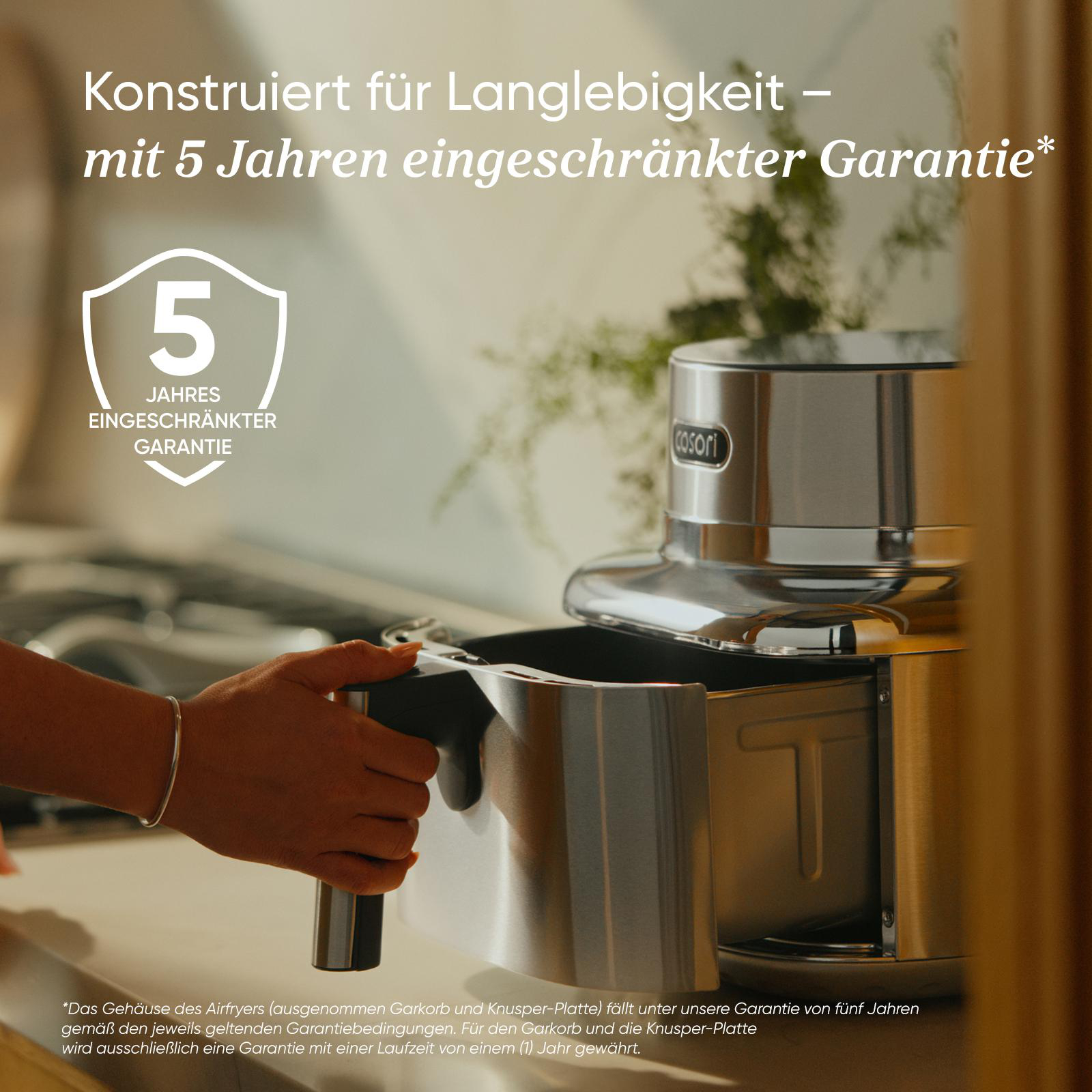 Ein silberner Airfryer mit einem Korb, der herausgezogen wird. 5 Jahre Garantie.
