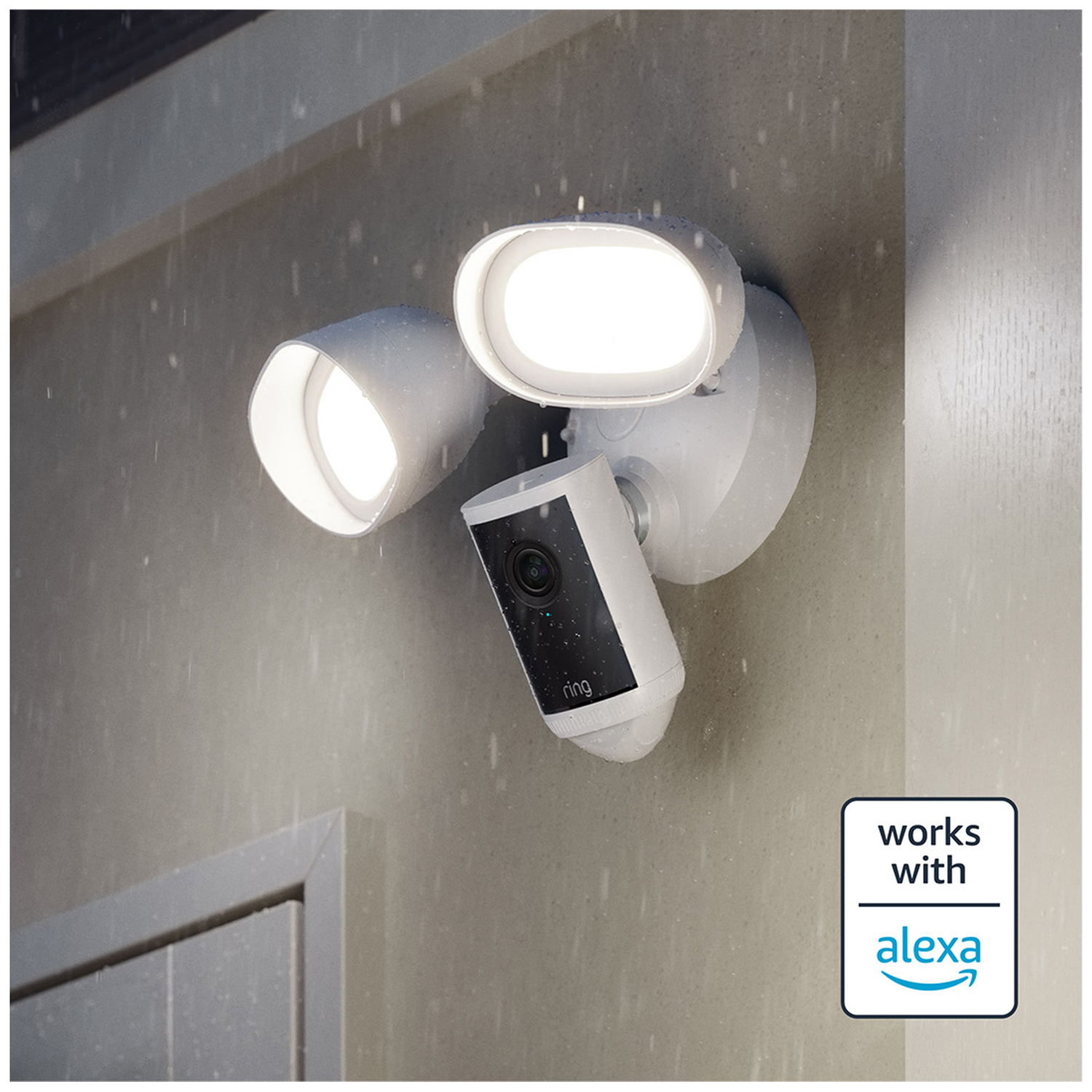 A white Ring floodlight camera motion detector shines in the rain.