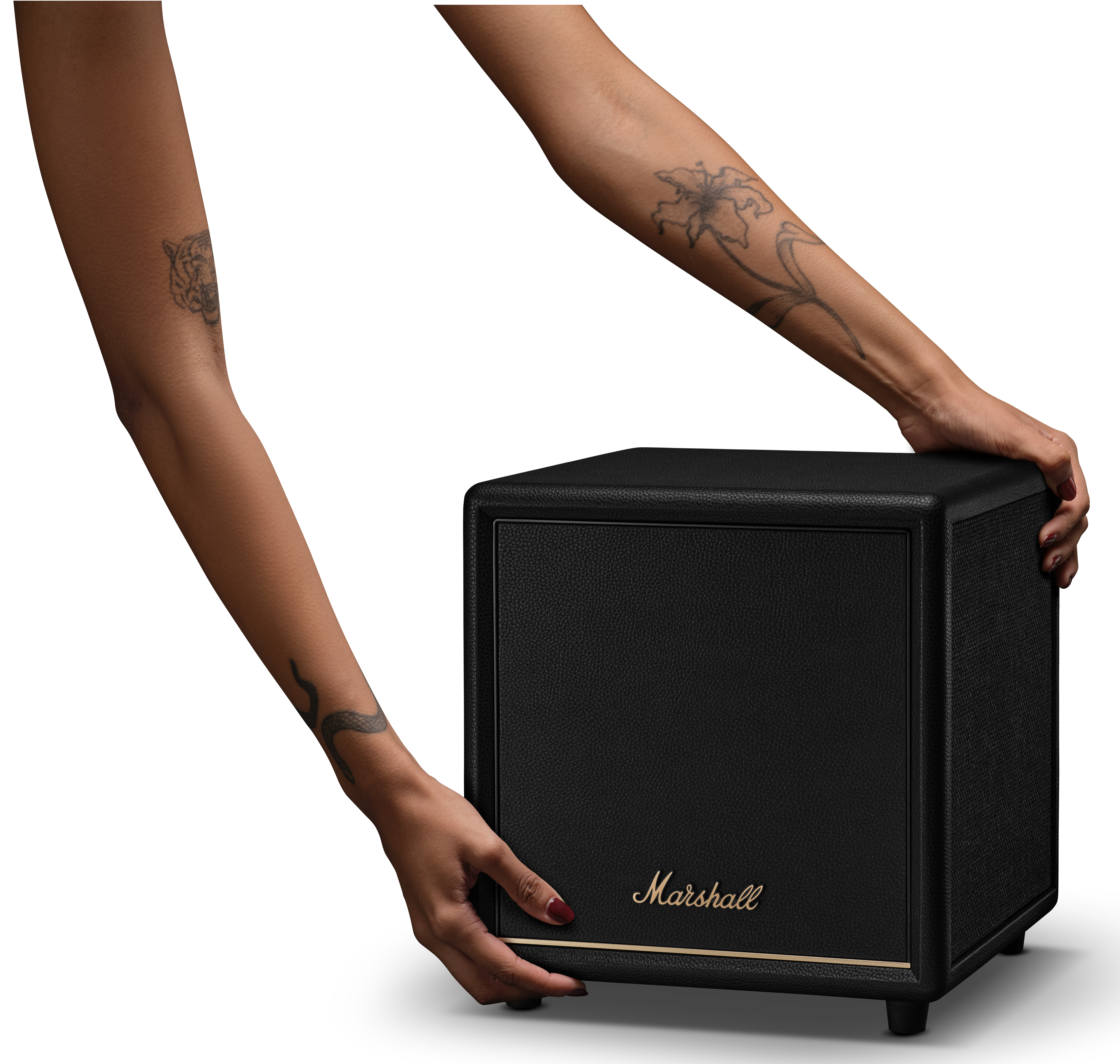 Dwa wytatuowane ramiona trzymają czarny głośnik Marshall. Białe tło.