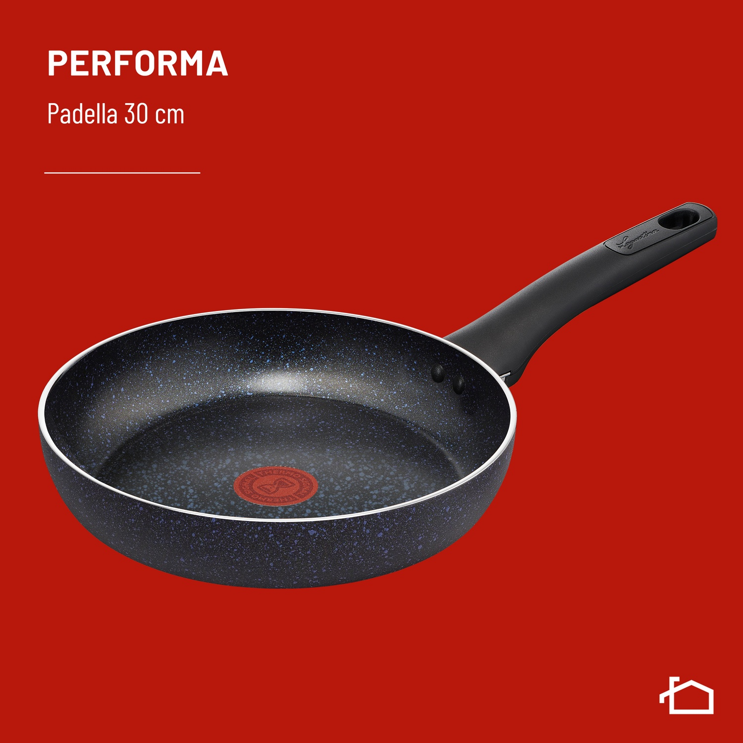 Una padella nera con macchie blu e bordo bianco su sfondo rosso.
