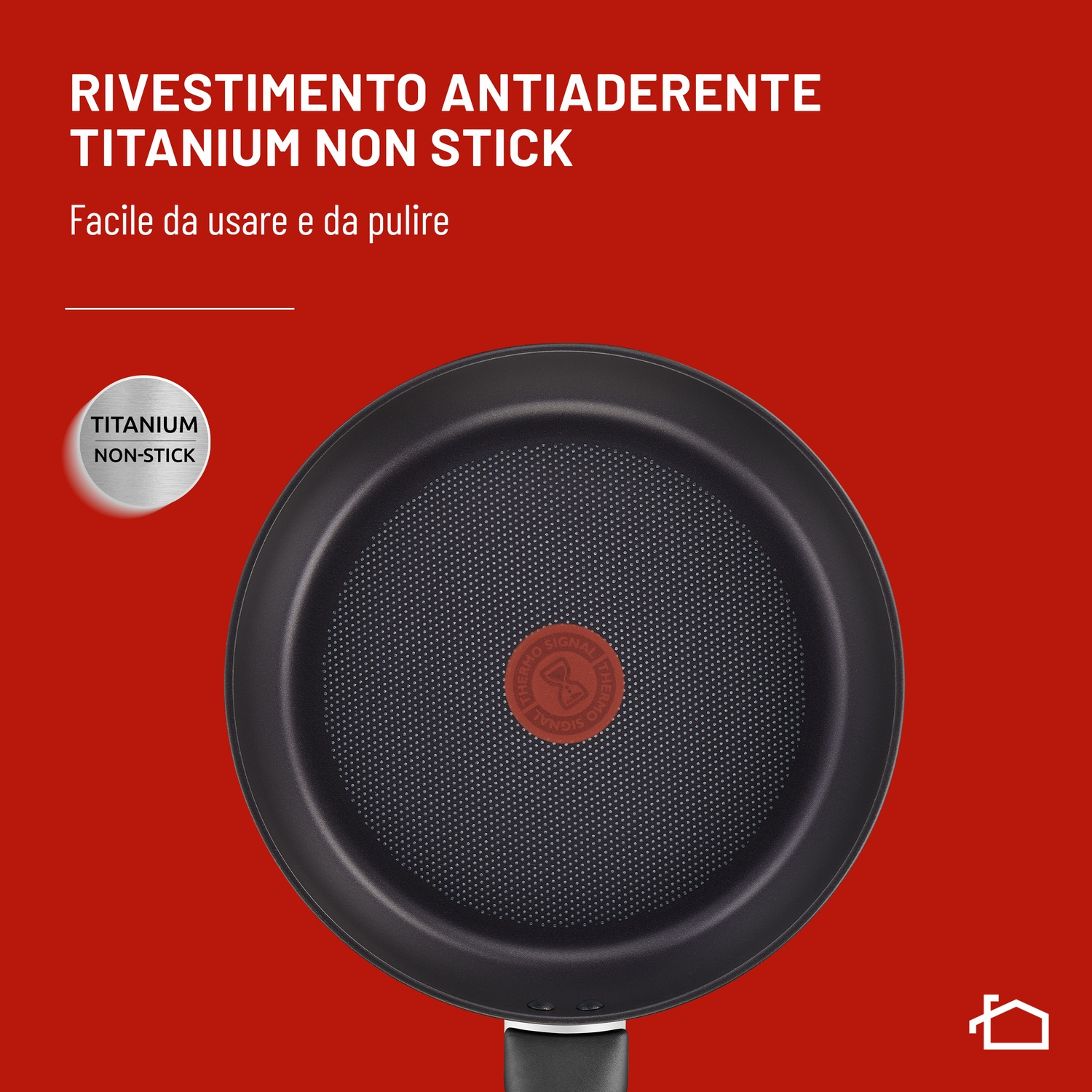 Una padella nera con rivestimento "Titanium Non-Stick" su sfondo rosso.