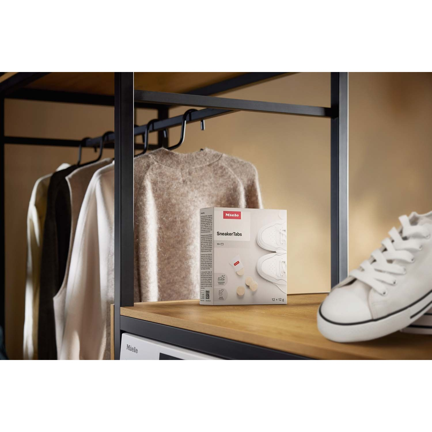 Una mensola con vestiti, Miele SneakerTabs e sneakers bianche.