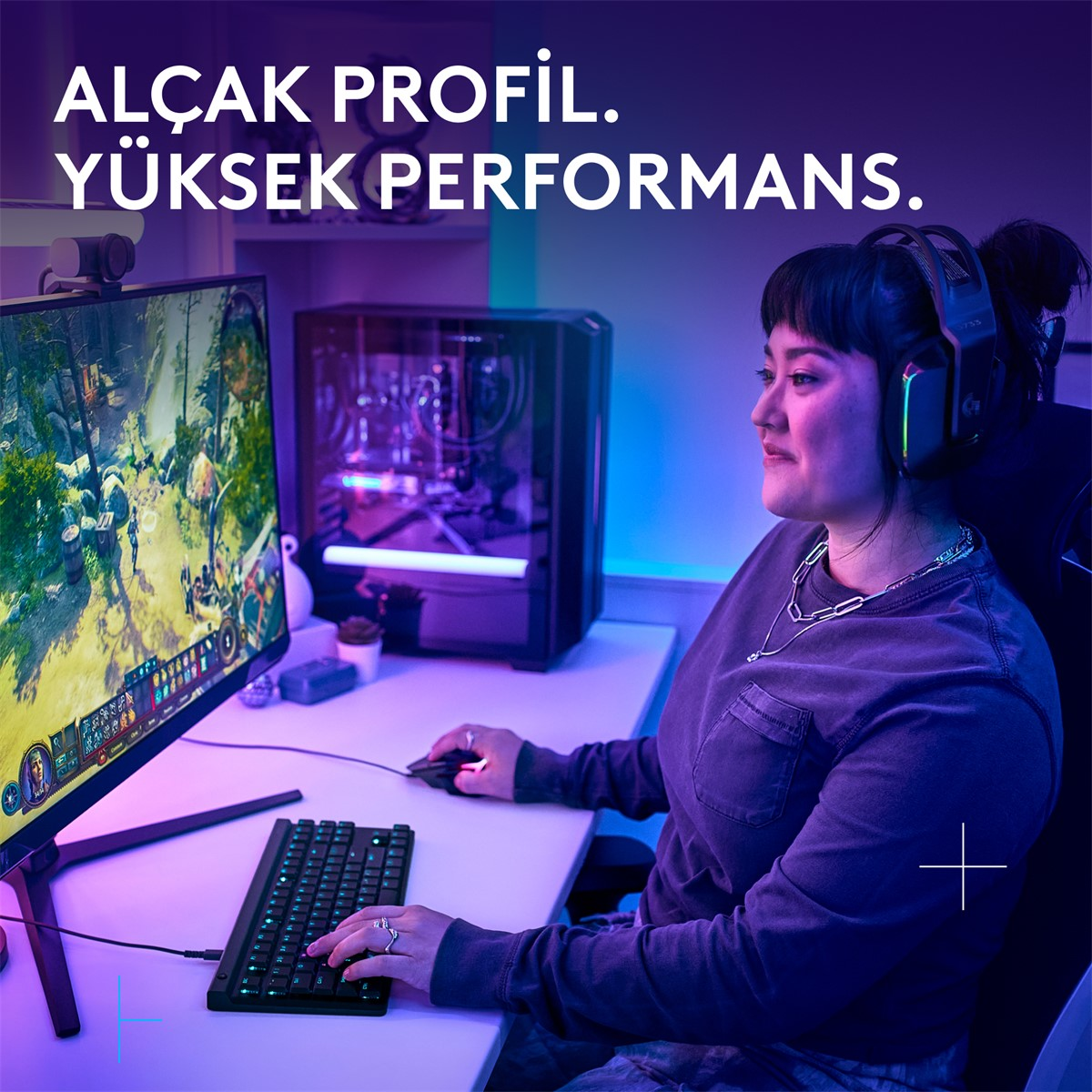 Kulaklıklı bir kadın RGB aydınlatmalı bilgisayarda oyun oynuyor.