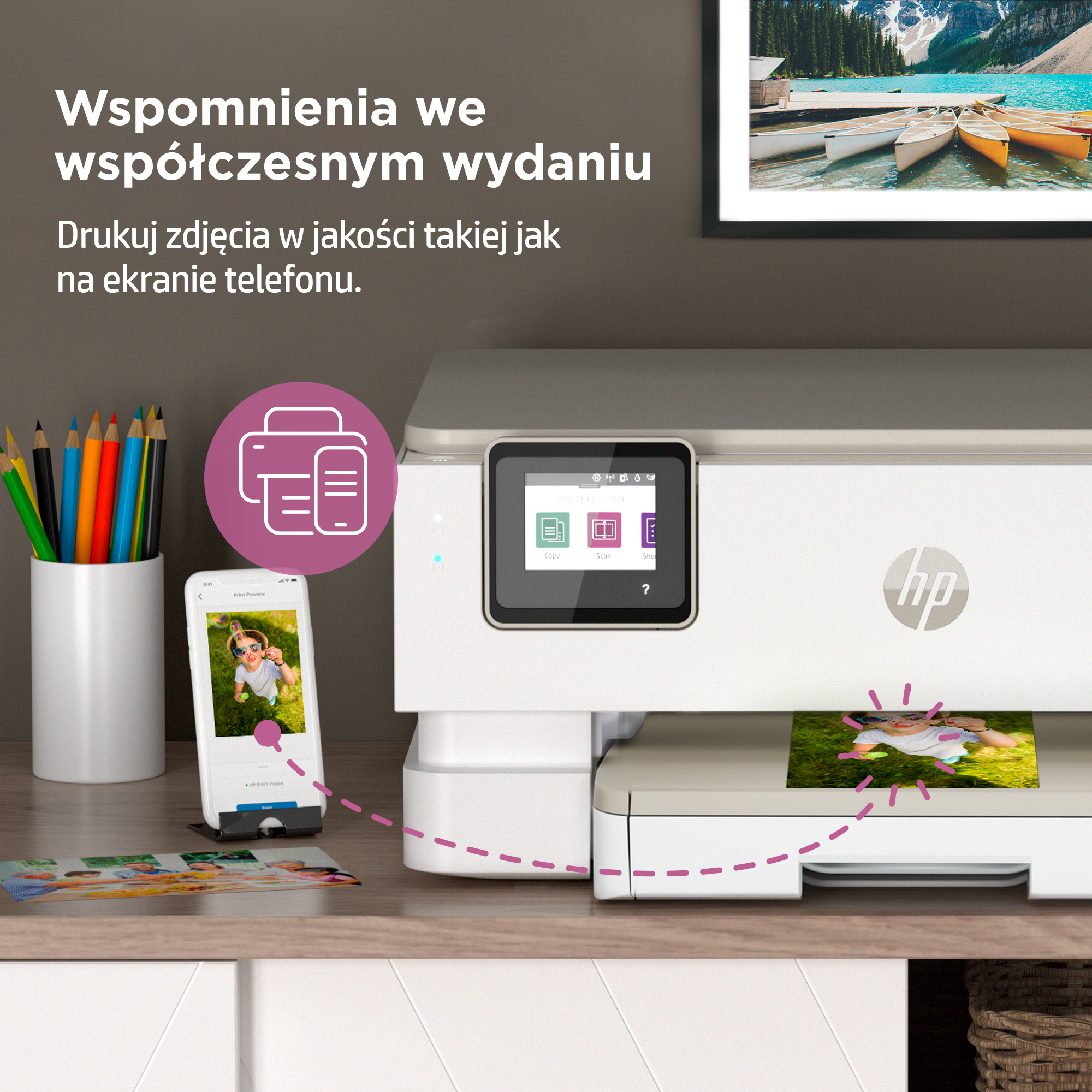 Drukarka z ekranem dotykowym, smartfon i pojemnik na kredki z kolorowymi kredkami.