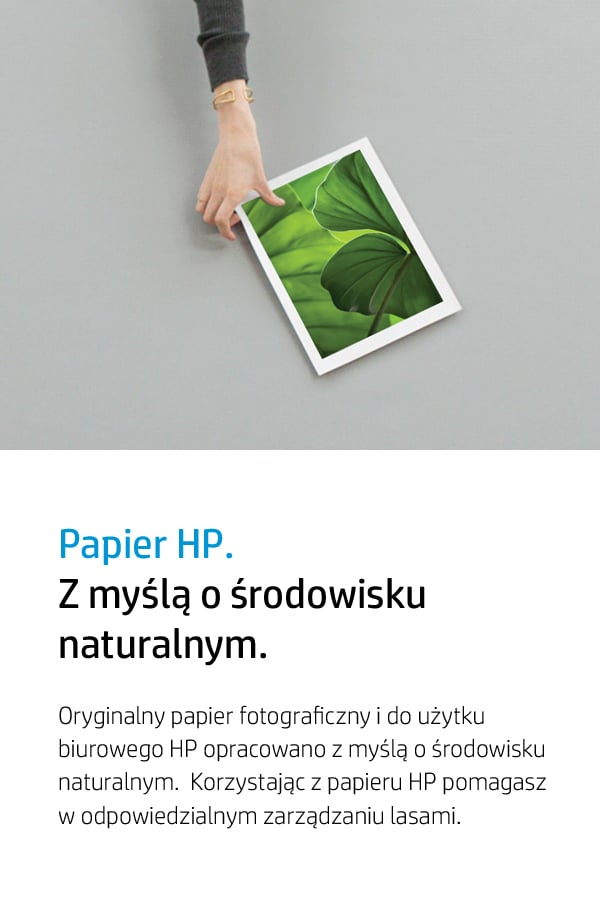 Dłoń trzyma papier z zielonymi liśćmi.