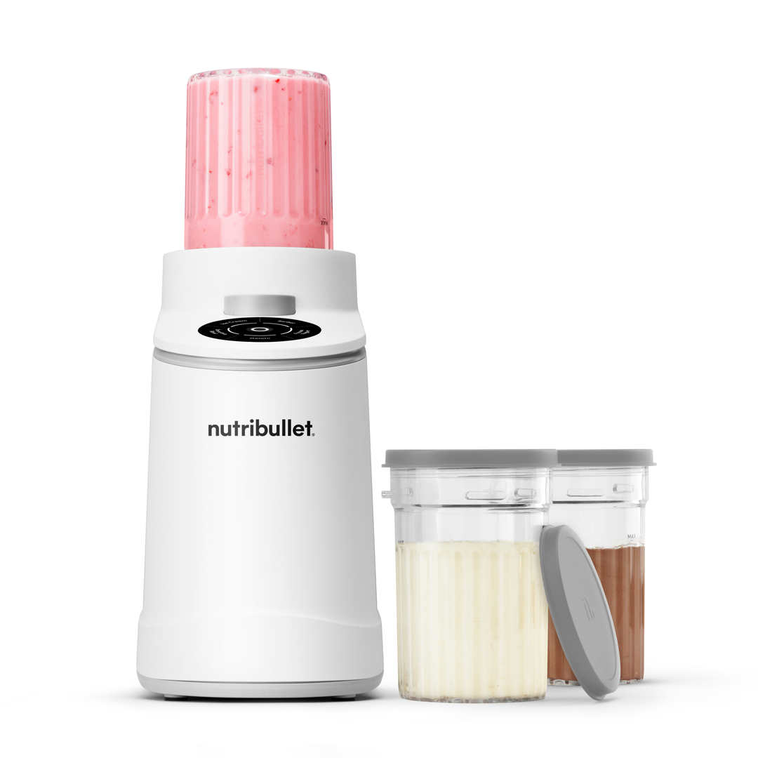 Ein weißer Nutribullet Mixer mit einem Glas Erdbeer-Smoothie und zwei Behältern.