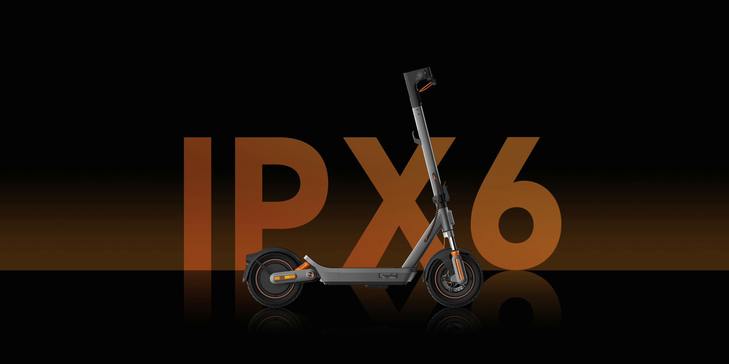 Ein grauer Elektroroller mit orangefarbenen Akzenten steht vor dem Schriftzug IPX6.