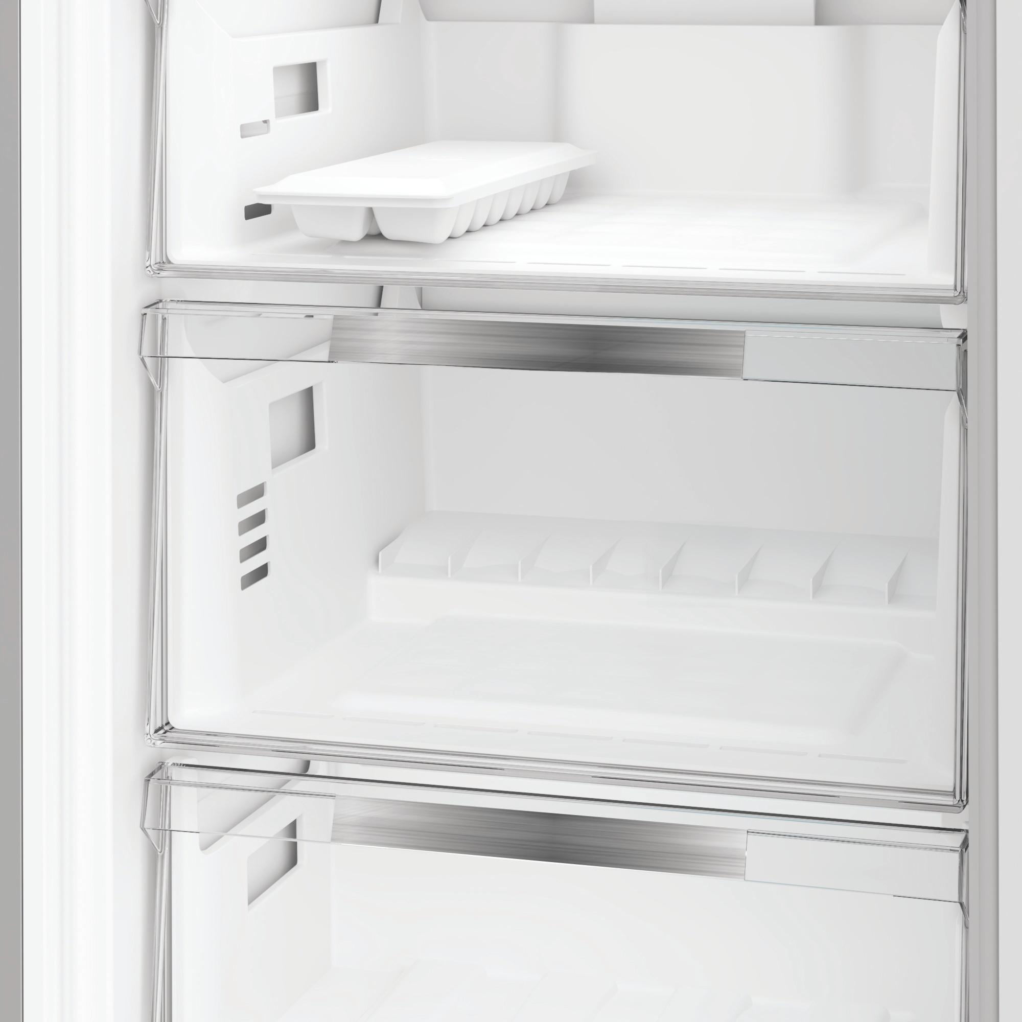 Ein leerer weißer Kühlschrank mit einem Eiswürfelbehälter auf dem obersten Regal.
