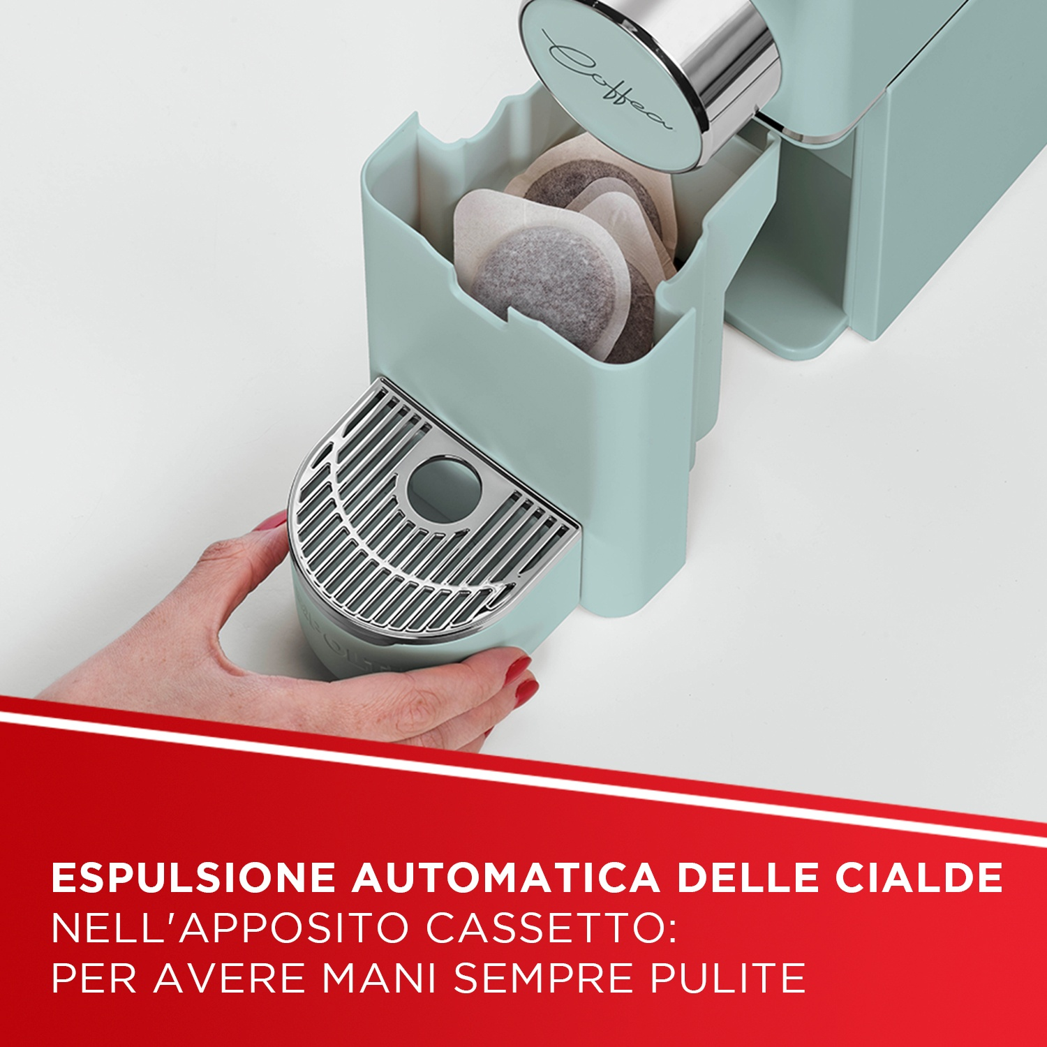 Una mano inserisce un cassetto per cialde in una macchina verde menta.