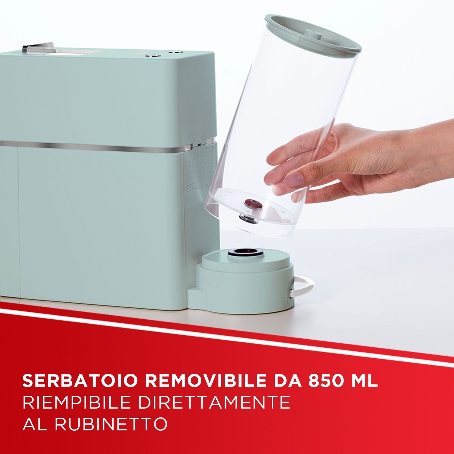 Un elettrodomestico verde chiaro con contenitore trasparente rimovibile in mano.