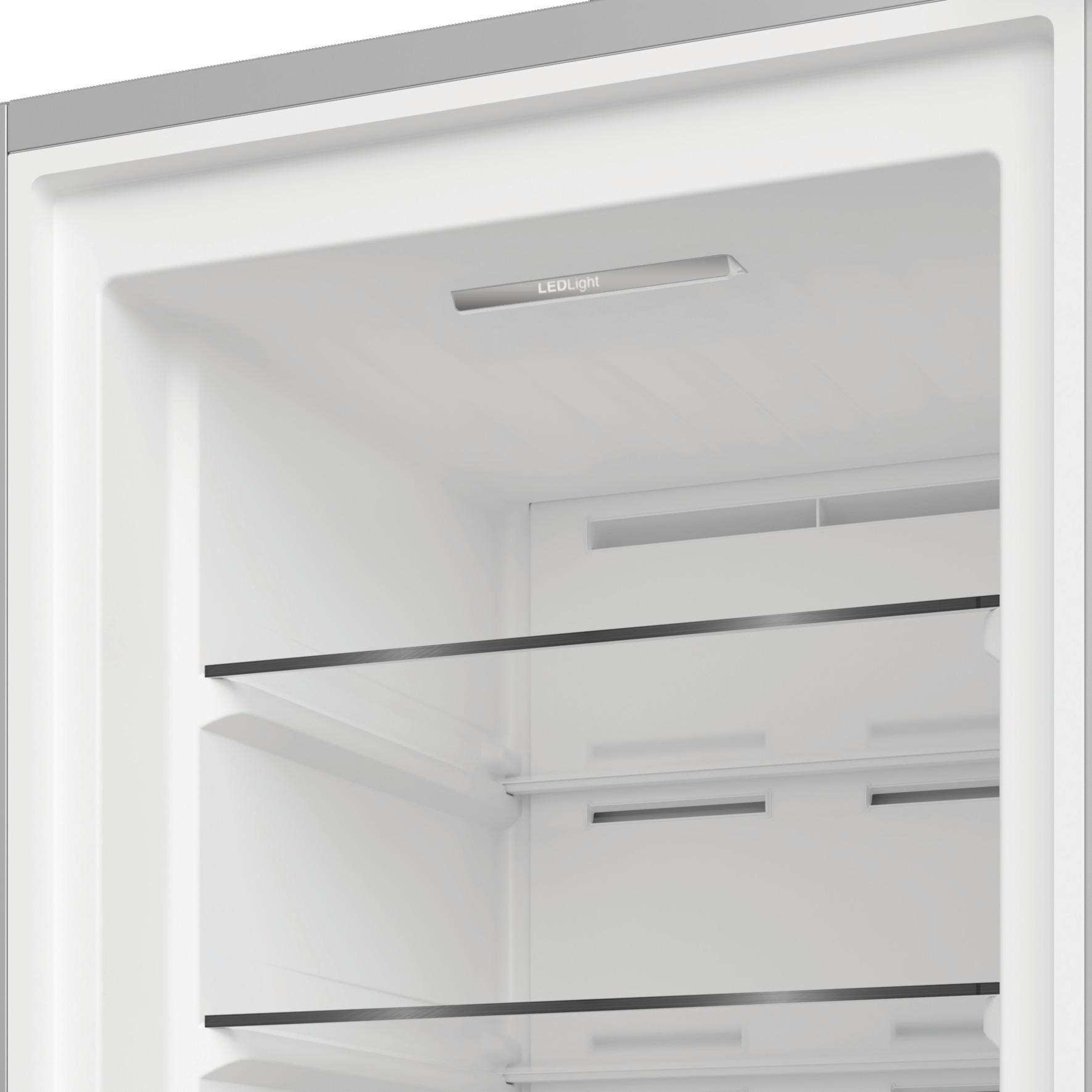 Innenraum eines Kühlschranks mit Glasregalen und LED-Beleuchtung.