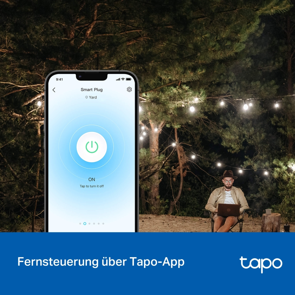 Mann sitzt mit Laptop im Freien, Handy zeigt App, Lichterketten leuchten.