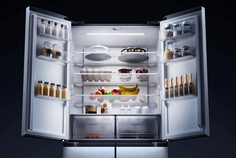 Otwarta lodówka z produktami spożywczymi na wielu półkach.