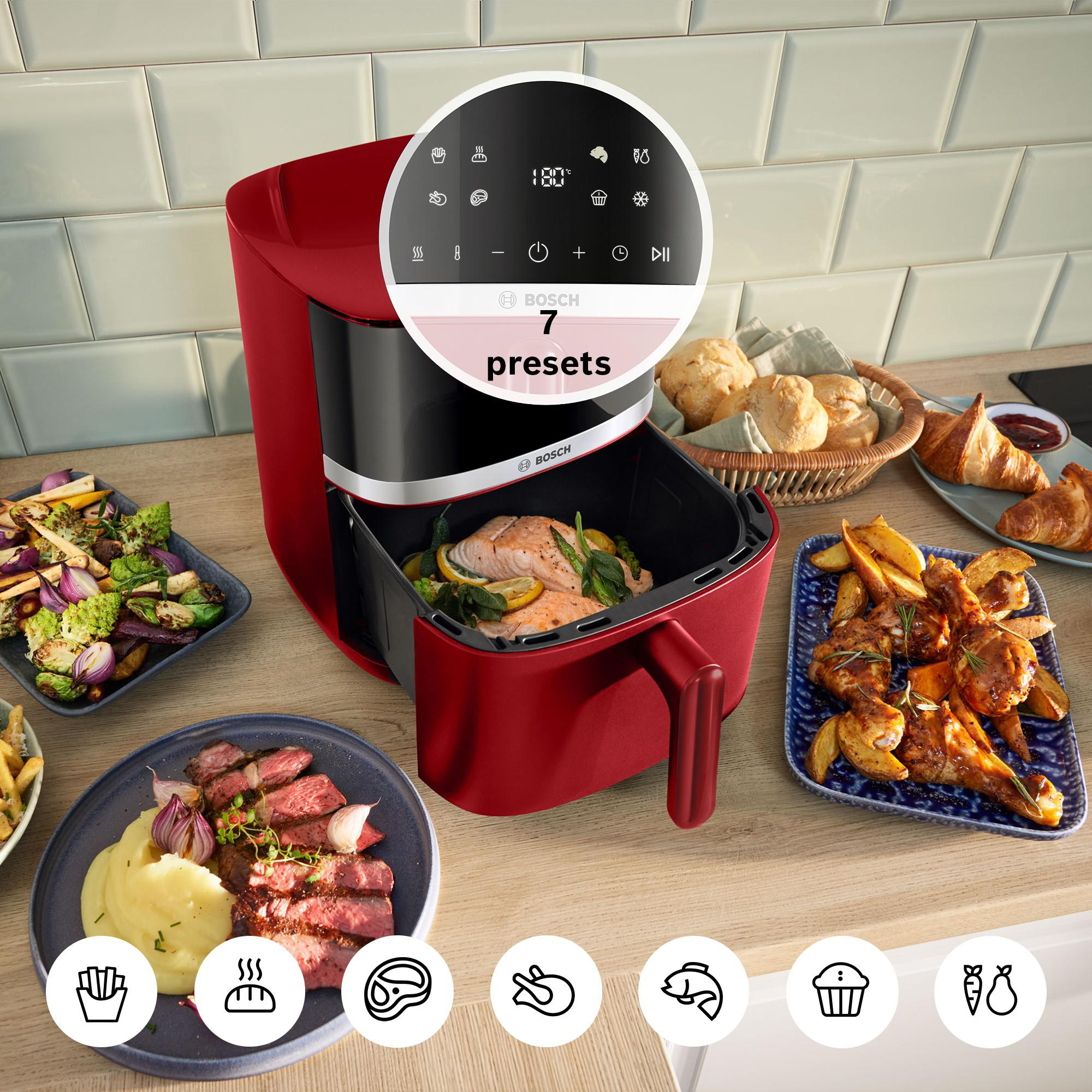 Ein roter Bosch Airfryer mit Lachs und Beilagen.