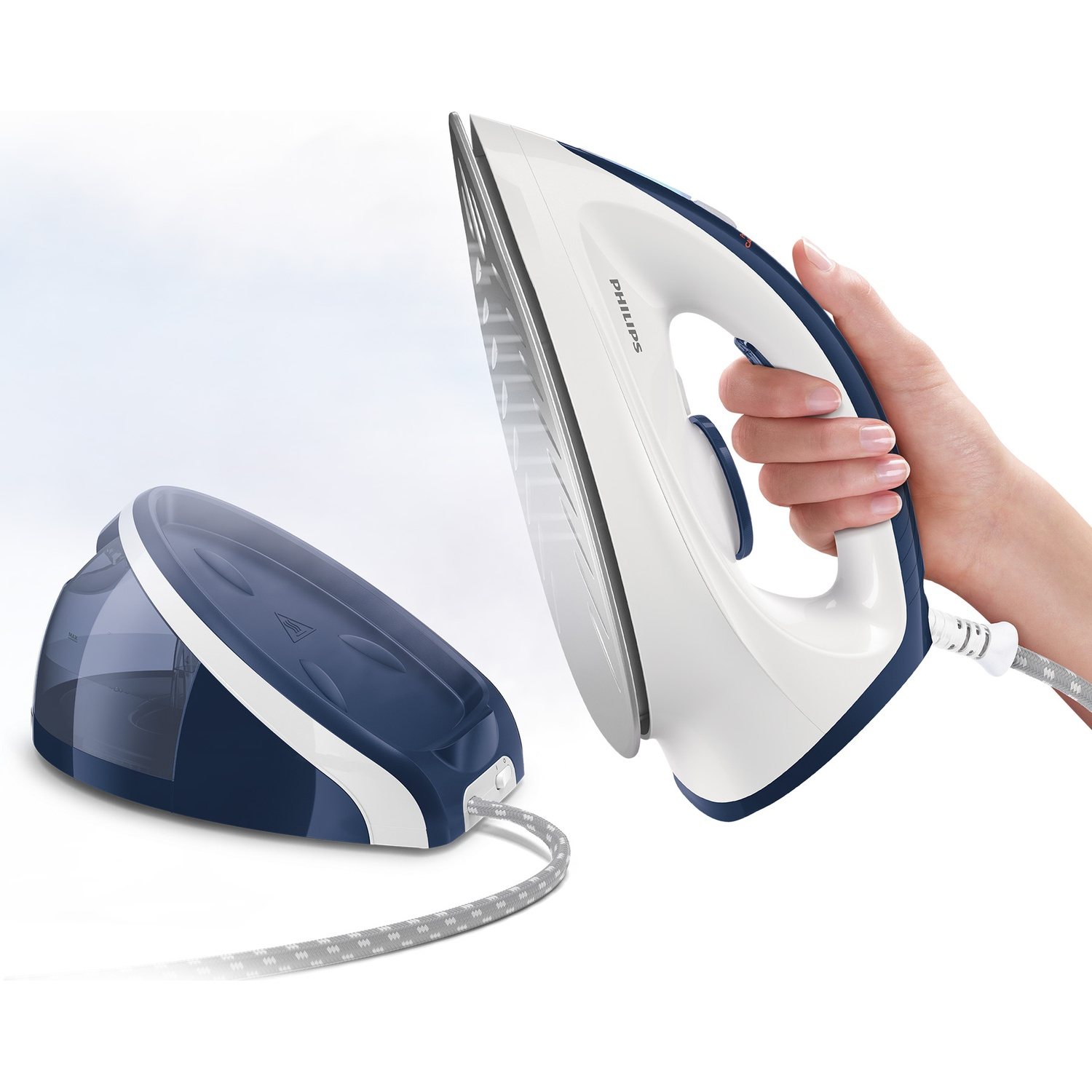 A hand holds a white and blue iron over a blue steam generator base.