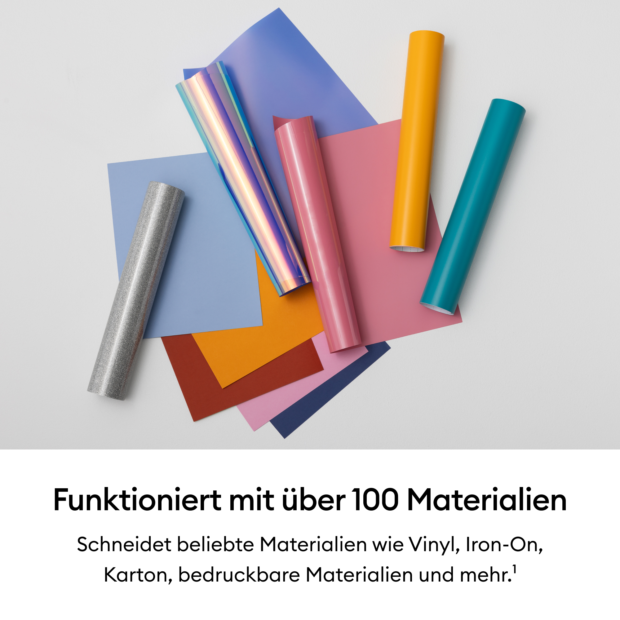 Rollen aus Vinyl in verschiedenen Farben und Glitzern auf Papierstapeln.
