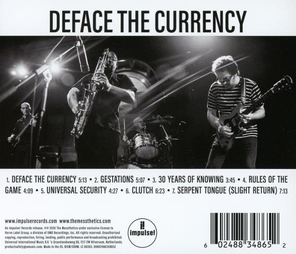 Band spielt live: Saxophonist, Gitarrist und Schlagzeuger. Albumtitel oben.