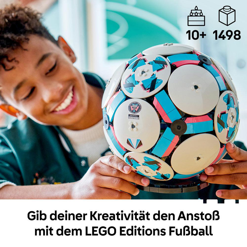 Ein Junge hält einen LEGO Fußball mit blau, pink und weißen Elementen.