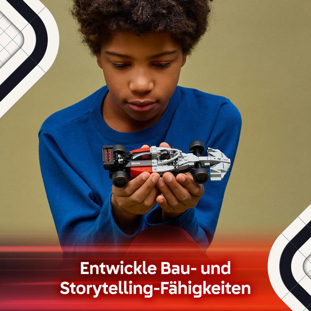 Ein Junge hält ein graues und rotes Lego-Rennauto in seinen Händen.