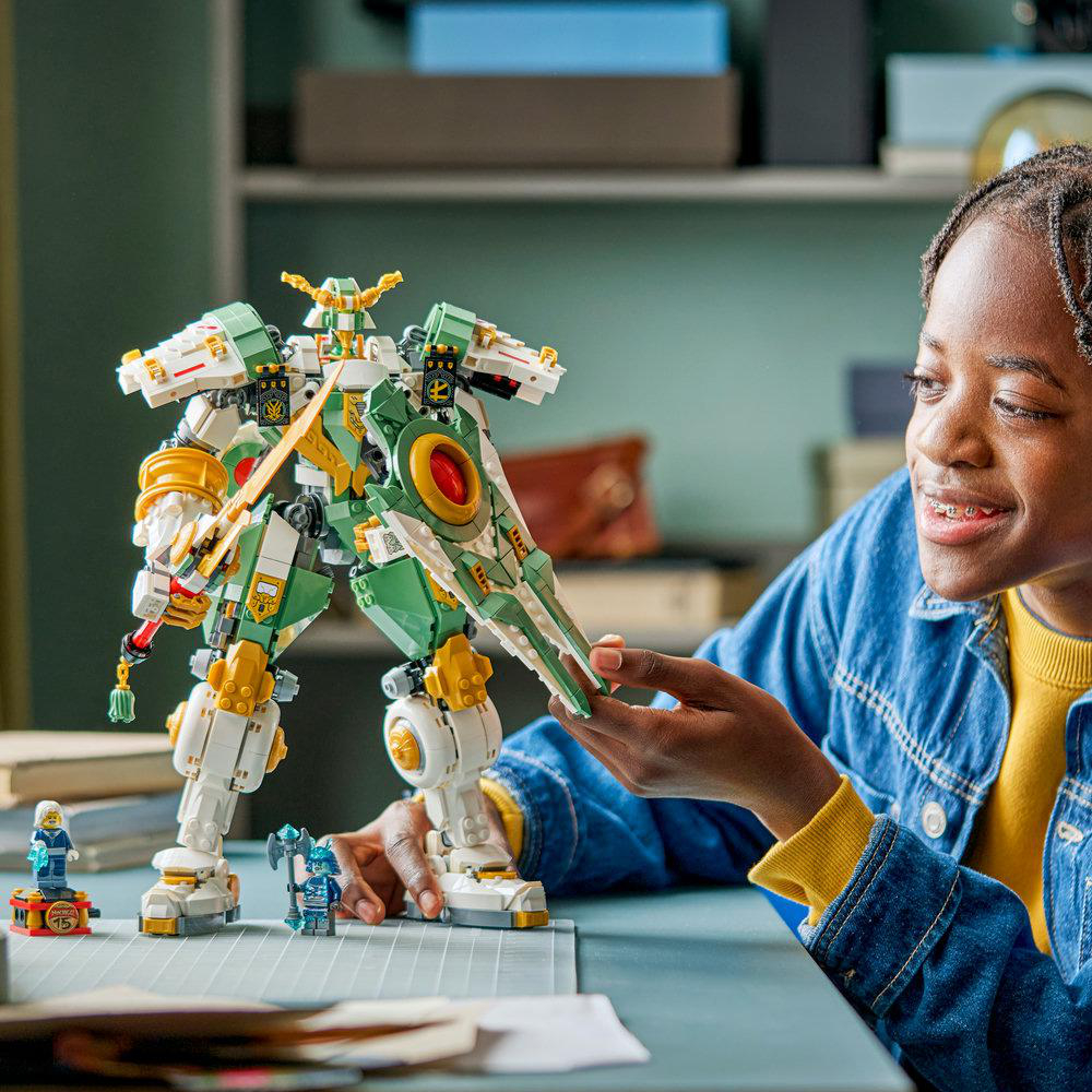 Ein Kind spielt mit einem grünen und weißen Lego-Mech mit einem Schwert und Schild.