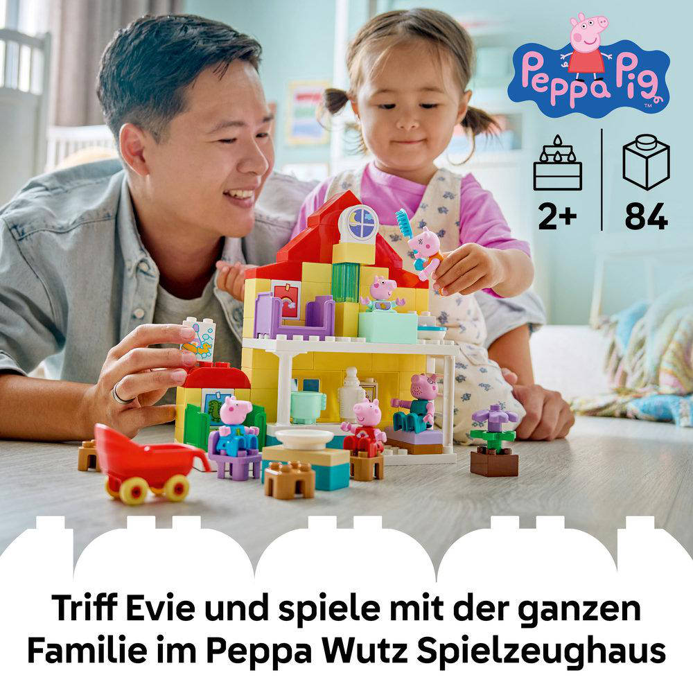 Ein Mann und ein Kind bauen ein Peppa Wutz Spielzeughaus aus bunten Klötzen.