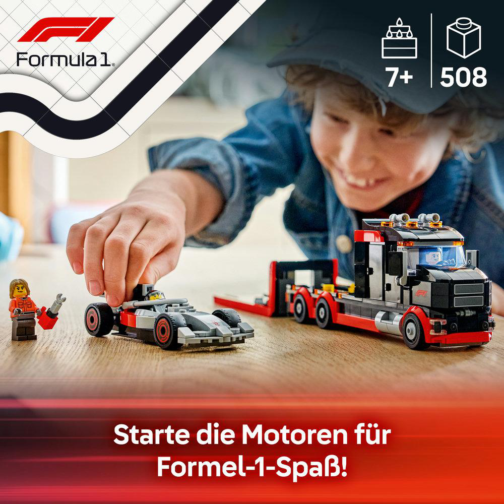 Ein Junge spielt mit Lego Formel 1 Autos und einem Lastwagen.