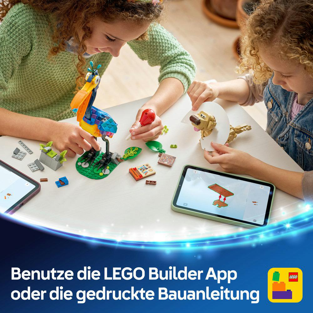 Zwei Mädchen bauen mit LEGO-Steinen, ein bunter Vogel steht im Fokus.