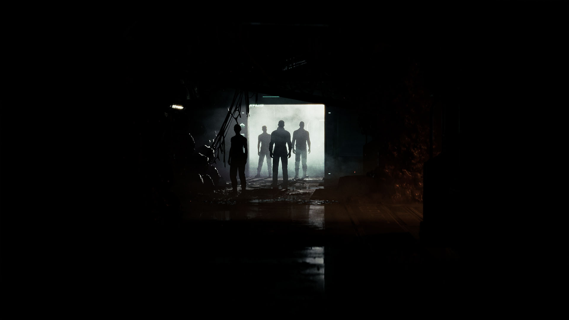 Sylwetki czterech osób stoją przed jasno oświetlonym przejściem w ciemnym, mglistym otoczeniu.