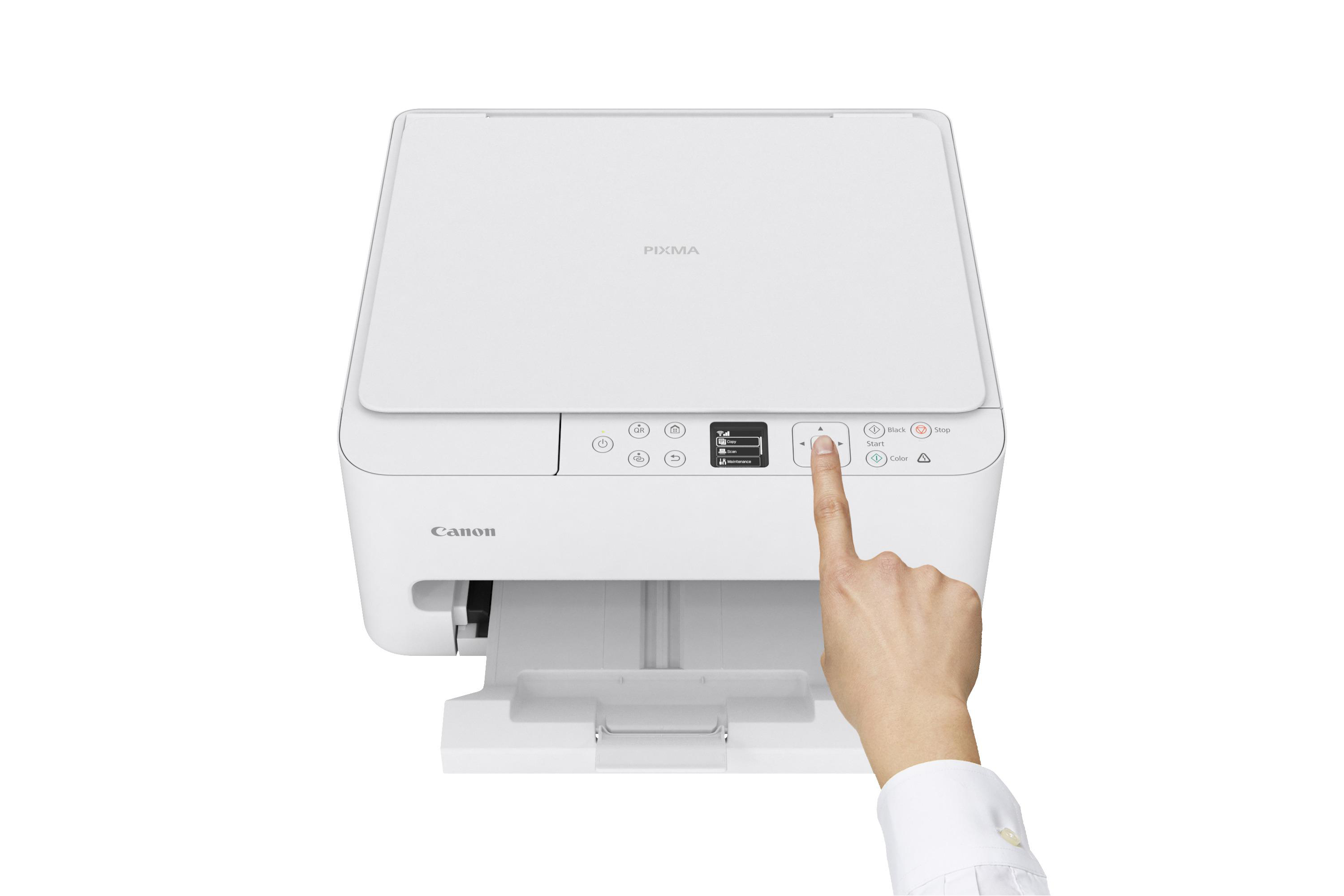 Eine Hand drückt auf einen Knopf eines weißen Canon Pixma Druckers.
