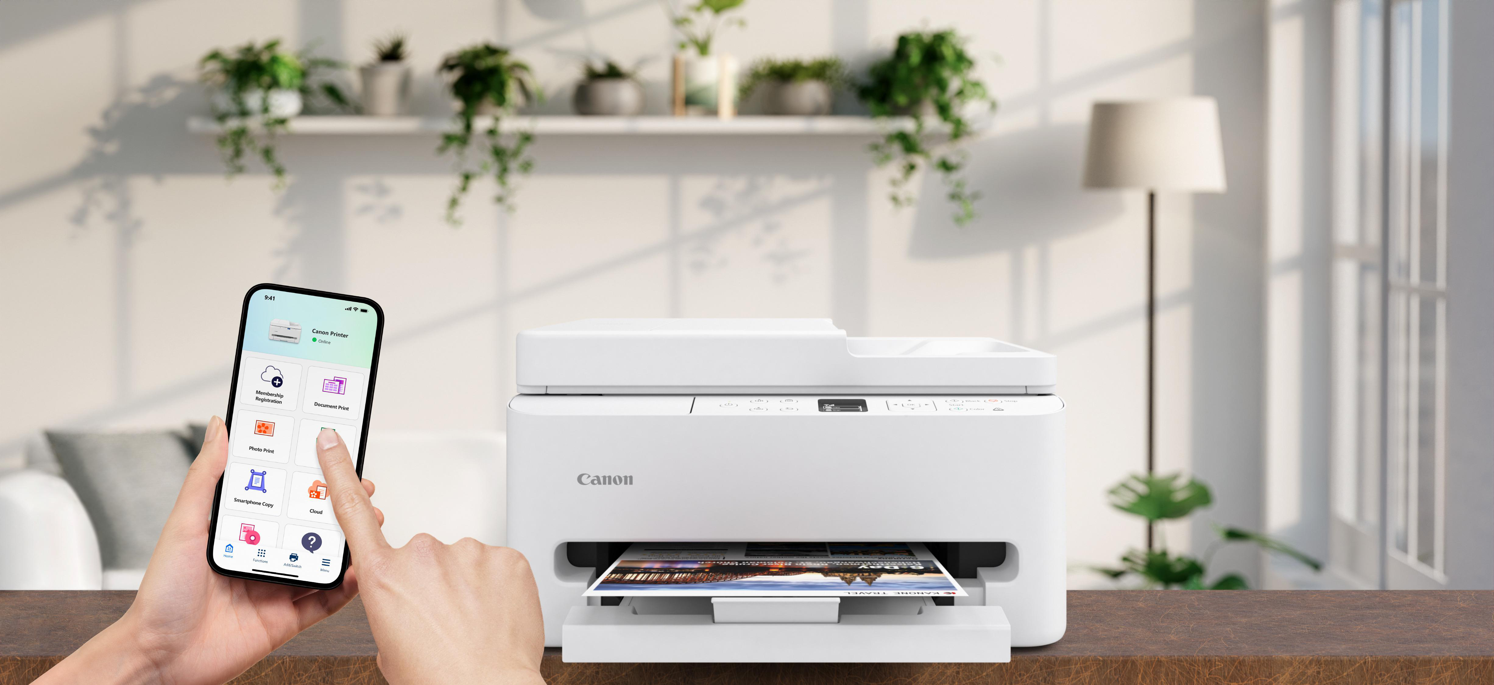 Eine Hand bedient ein Smartphone mit Drucker-App neben einem weißen Canon-Drucker.