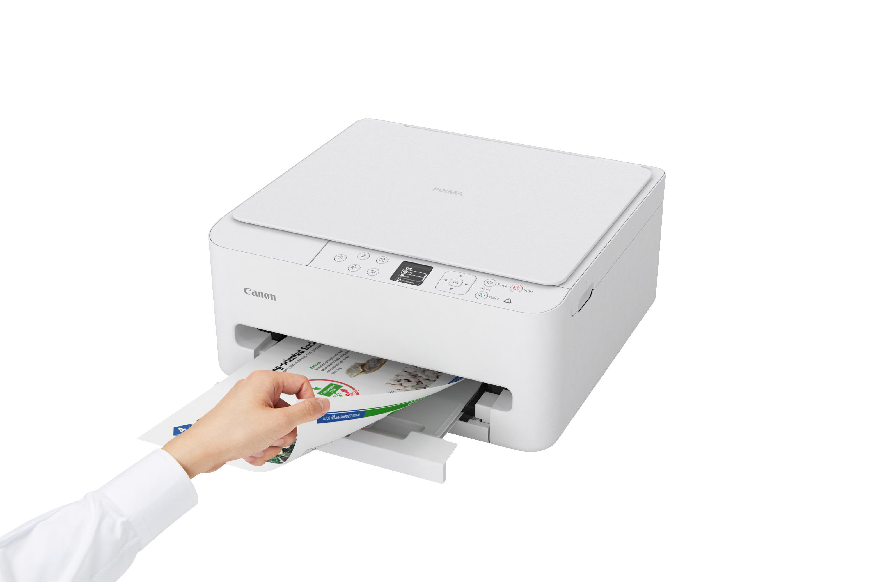Eine Hand führt ein Blatt Papier in einen weißen Canon Pixma Drucker ein.