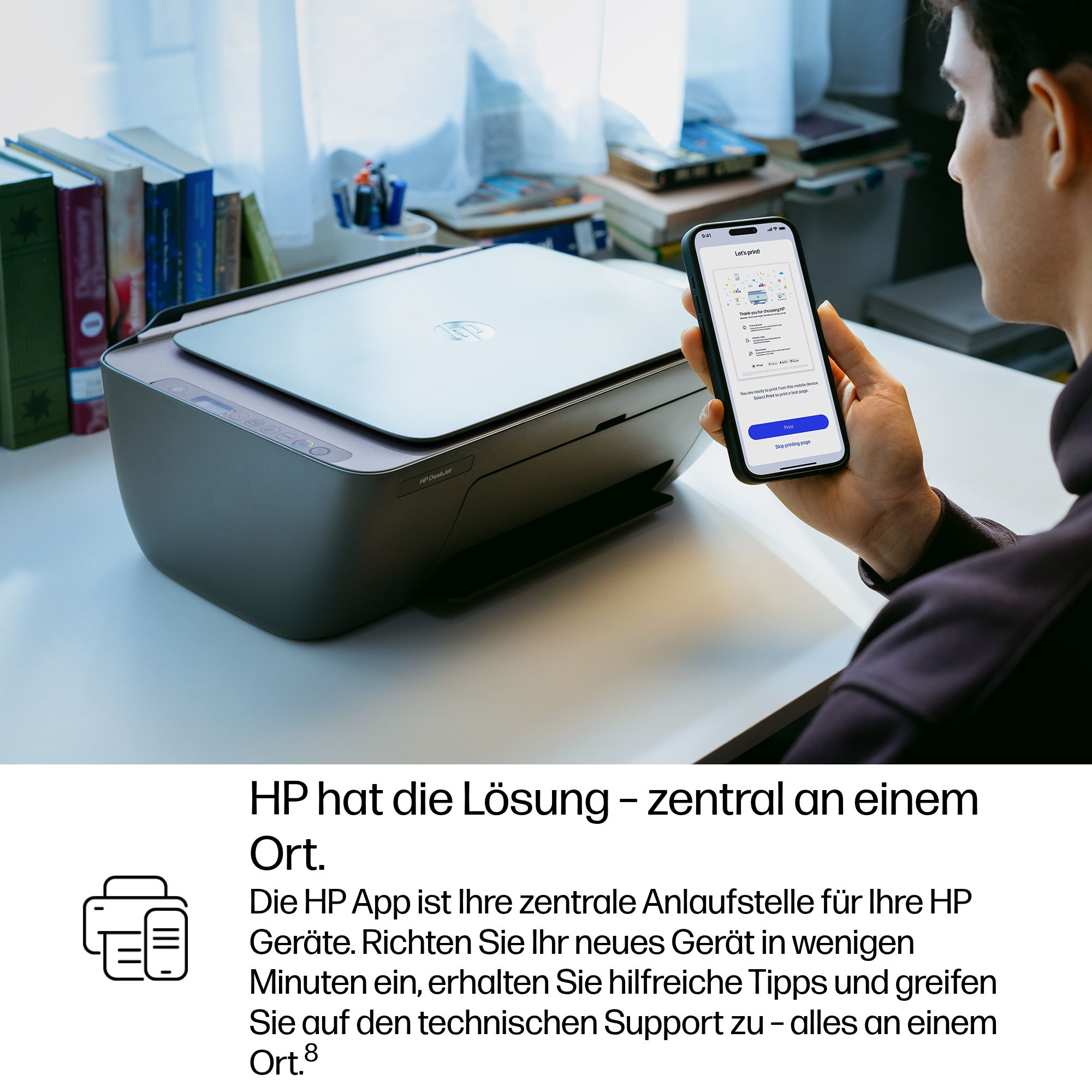 Ein Mann hält ein Smartphone vor einen HP Drucker. Der Bildschirm zeigt die HP App.