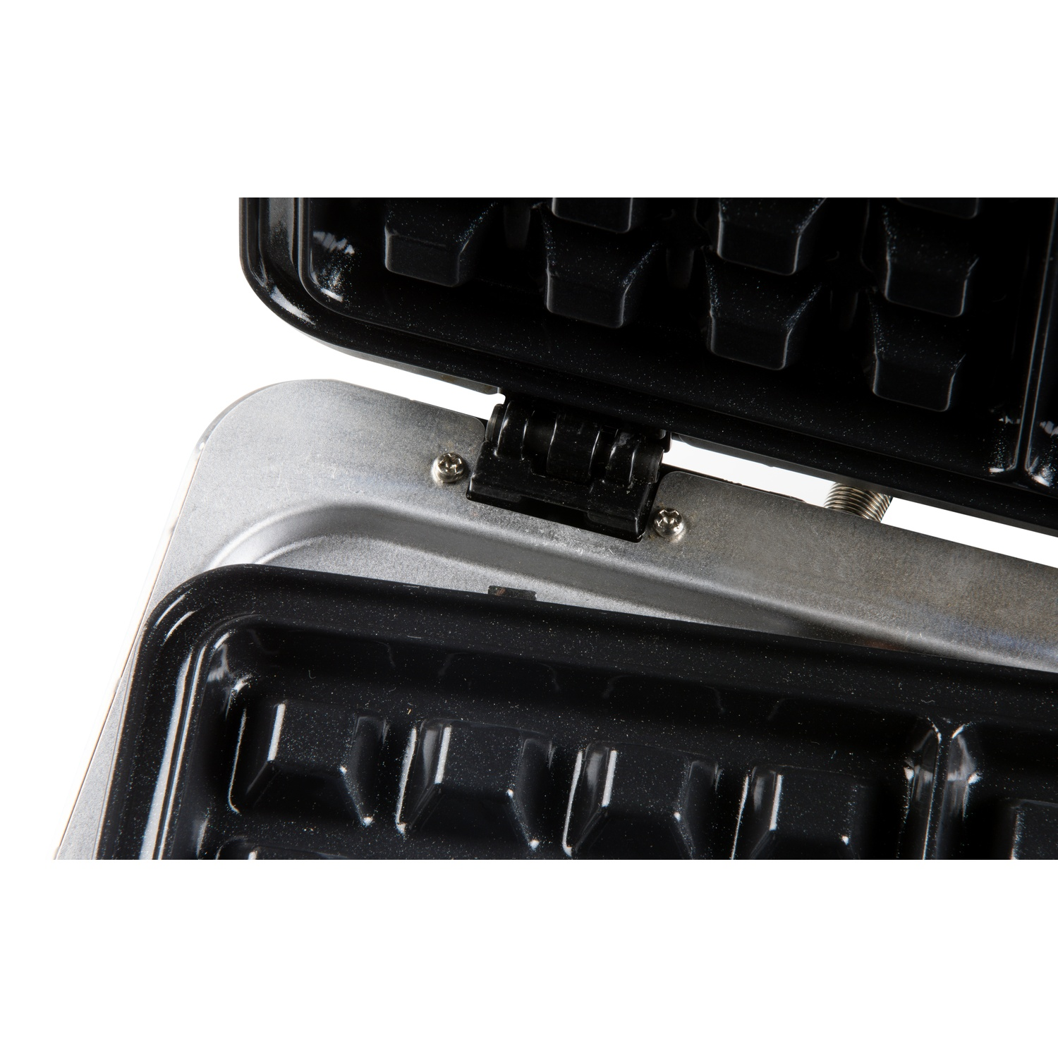 Close-up of an open waffle maker showing black heating plates and silver casing.