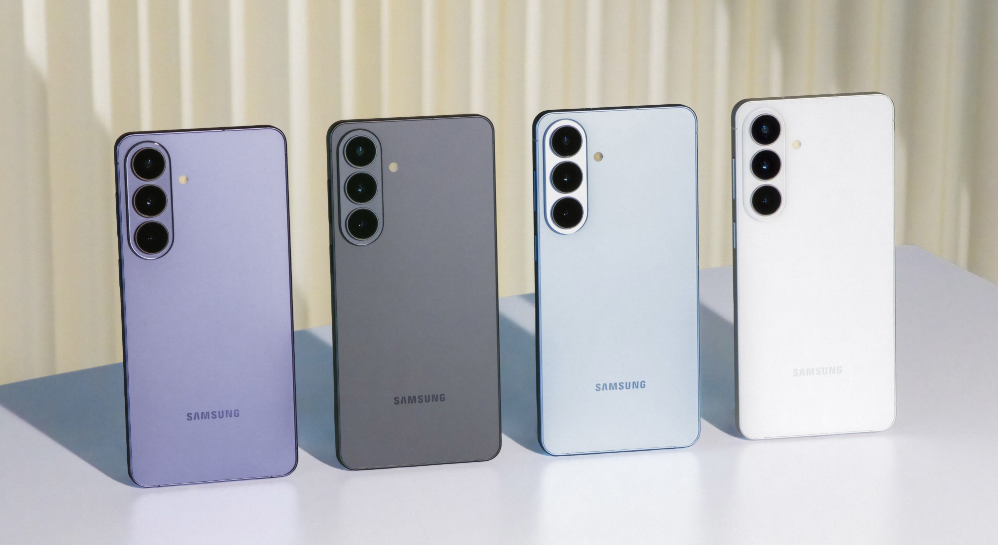 Cztery telefony Samsung w kolorach fioletowym, szarym, jasnoniebieskim i białym obok siebie.