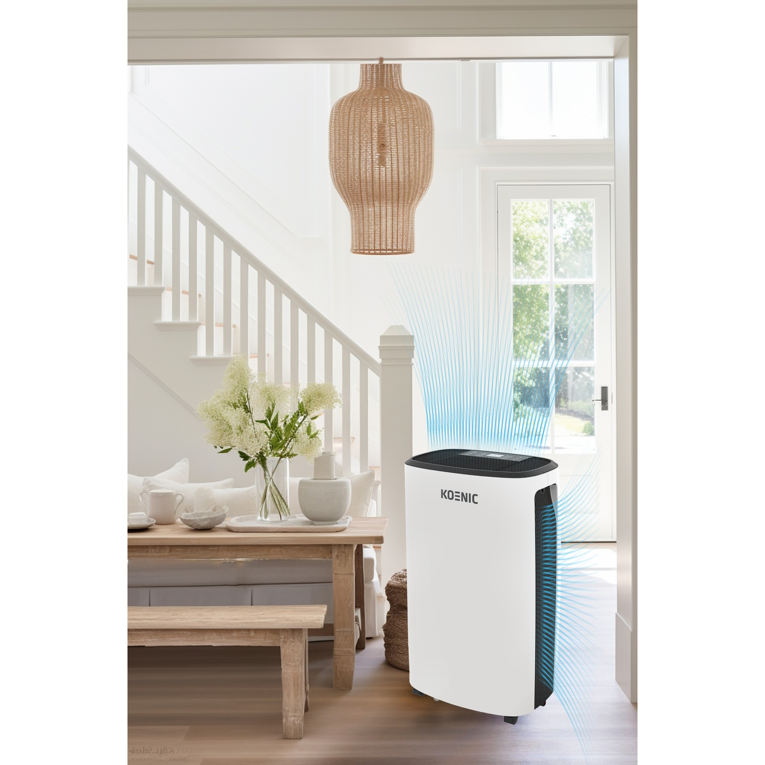 Un purificatore d'aria bianco con flussi d'aria blu si trova vicino a un tavolo di legno e scale.