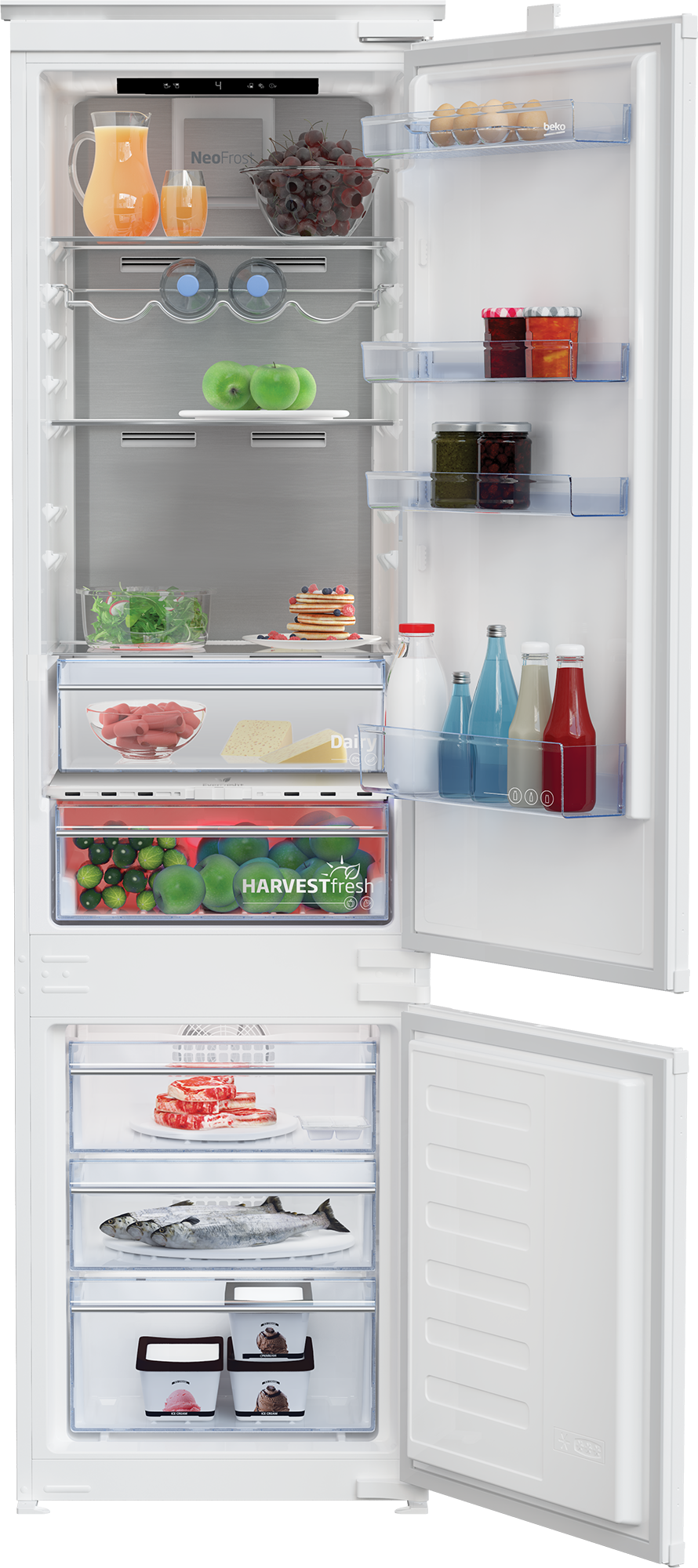 Otwarta biała lodówka z sokiem, owocami, jajkami, dżemami, mięsem i rybami.