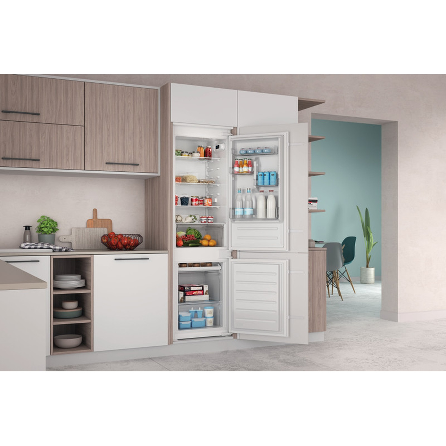 Un frigorifero aperto con cibo e bevande in una cucina moderna.