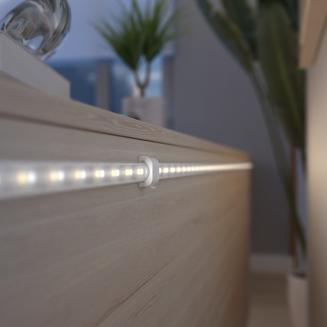 Eine LED-Lichtleiste ist an einer Holzoberfläche befestigt. Pflanzen sind im Hintergrund.