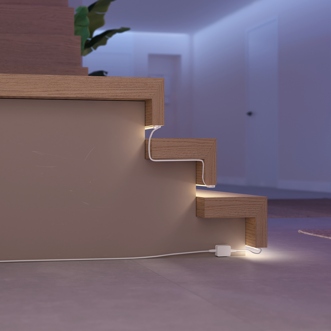 Holztreppe mit indirekter Beleuchtung und weißem Kabel, das zum Netzteil führt.