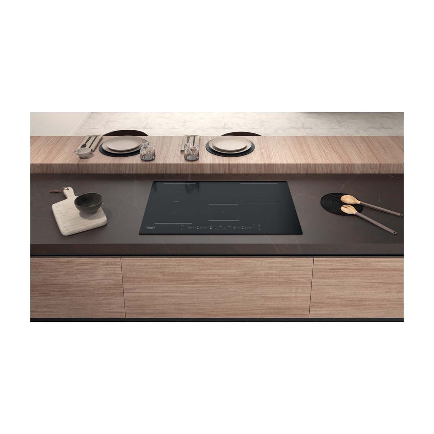 Un piano cottura a induzione moderno con mobili in legno e piatti.