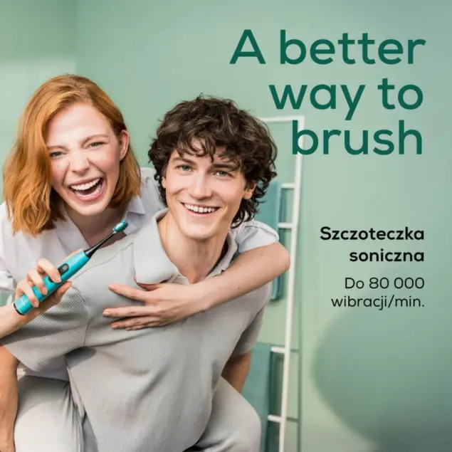 Mężczyzna i kobieta śmieją się, ona trzyma szczoteczkę.