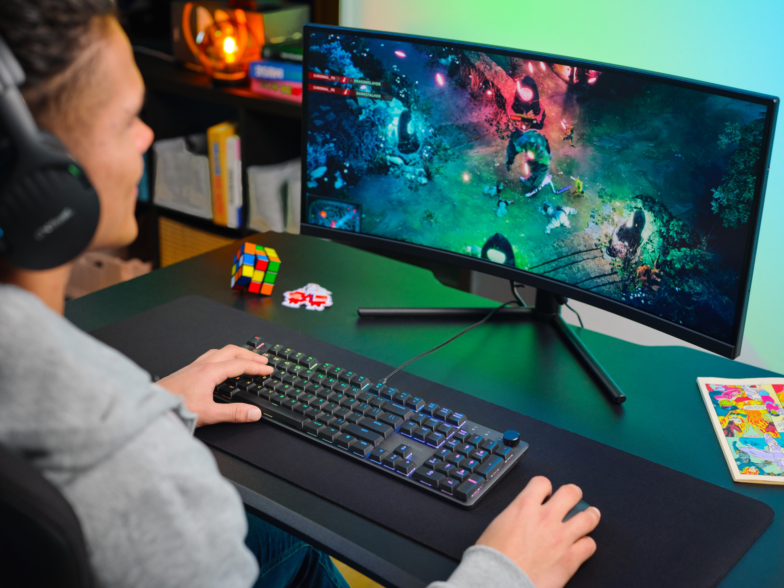 Osoba w słuchawkach gra w grę wideo na zakrzywionym monitorze.